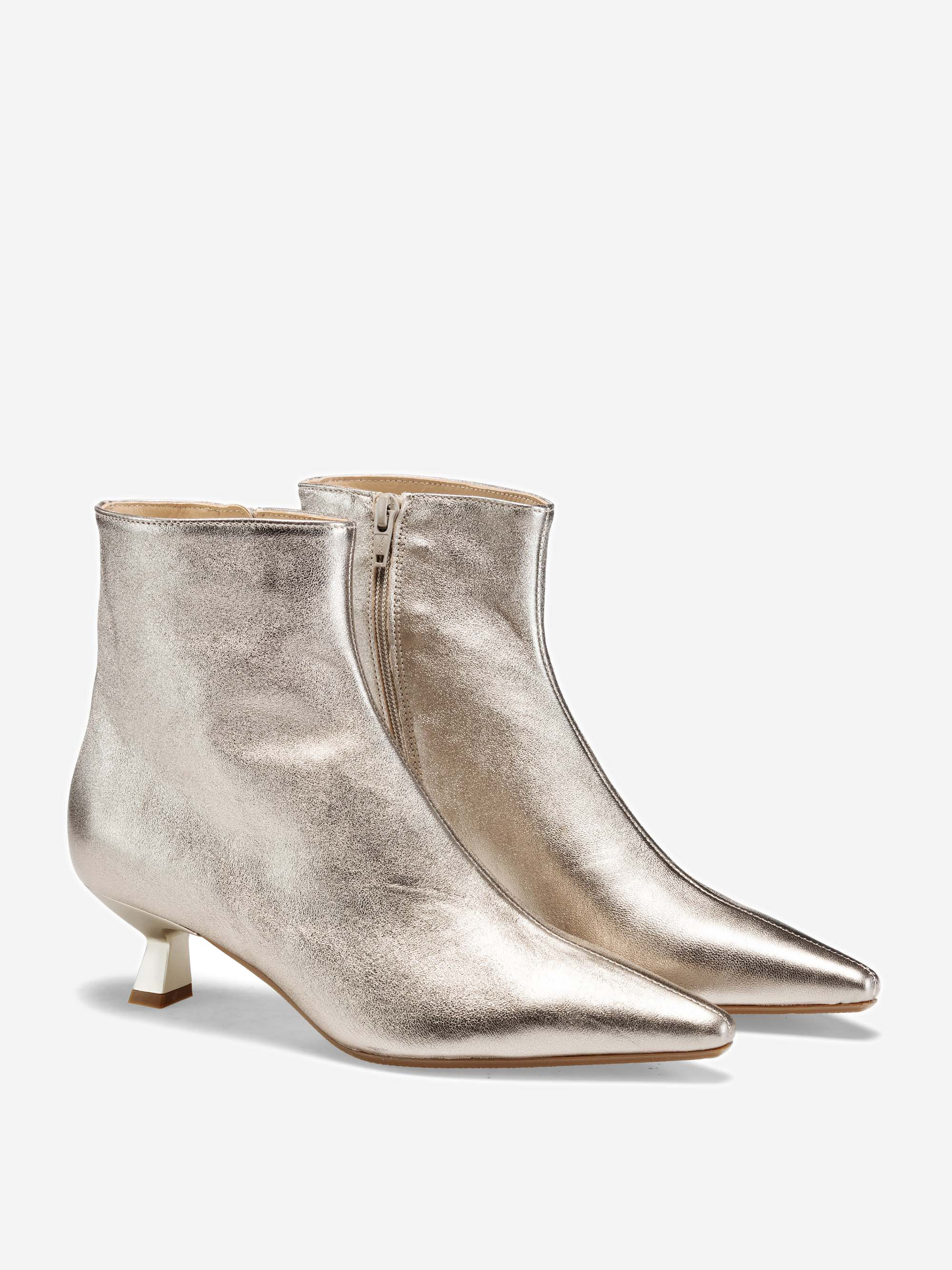Ein Paar goldfarbene, metallisch glänzende Stiefeletten mit spitzen Zehen, niedrigem Kitten-Heel und seitlichen Reißverschlüssen, die vor einem schlichten weißen Hintergrund stehen.