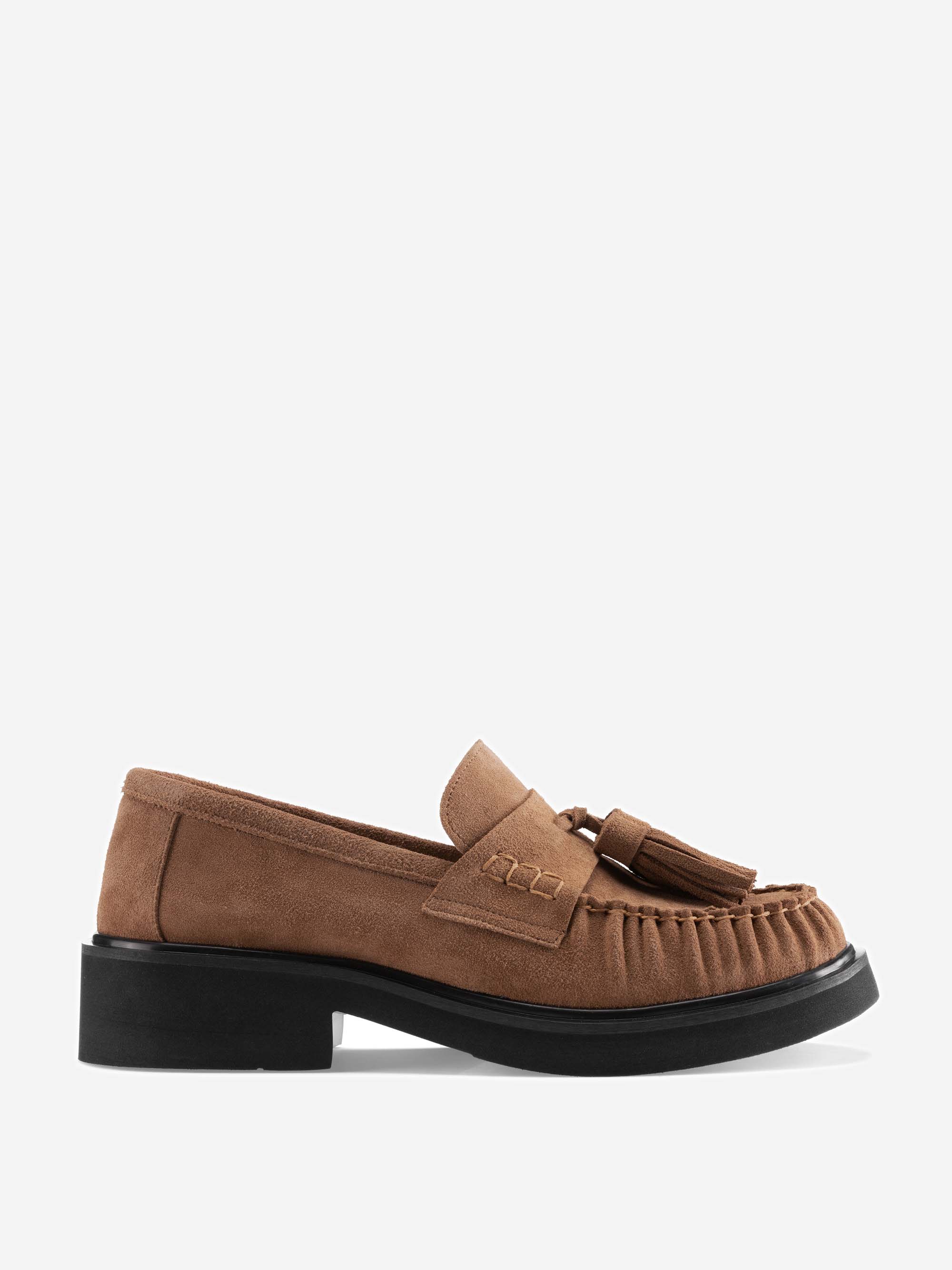 Brauner Loafer aus Wildleder mit Quasten an der Vorderseite, Mokassin-Nähten und einer dicken schwarzen Sohle, präsentiert vor einem schlichten weißen Hintergrund.