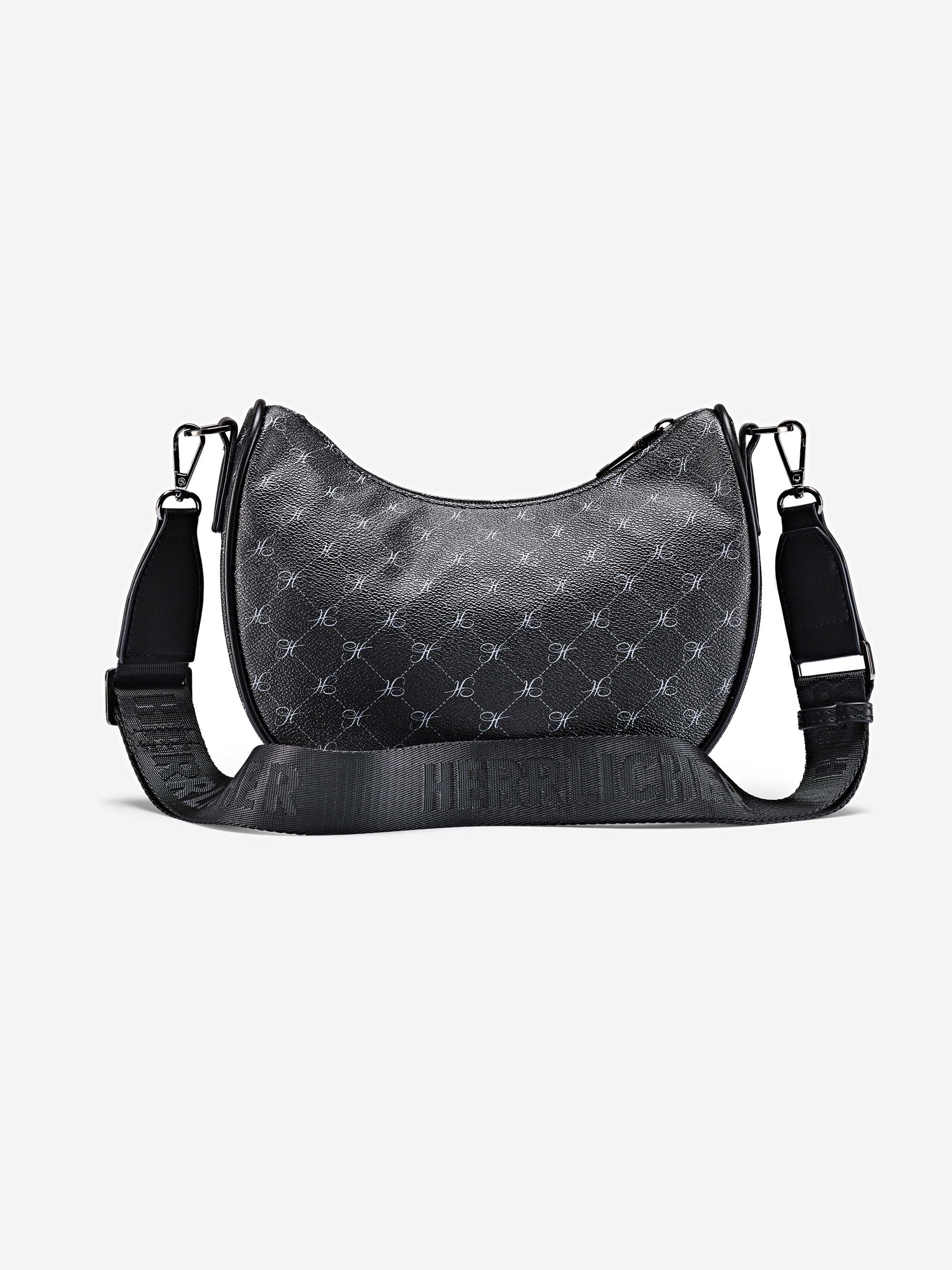 Schwarze, halbmondförmige Crossbody-Tasche mit dezentem, sich wiederholendem Muster, silberfarbener Hardware und einem verstellbaren, schwarzen Riemen mit geprägtem Textdesign. Die Tasche ist vor einem schlichten weißen Hintergrund platziert.