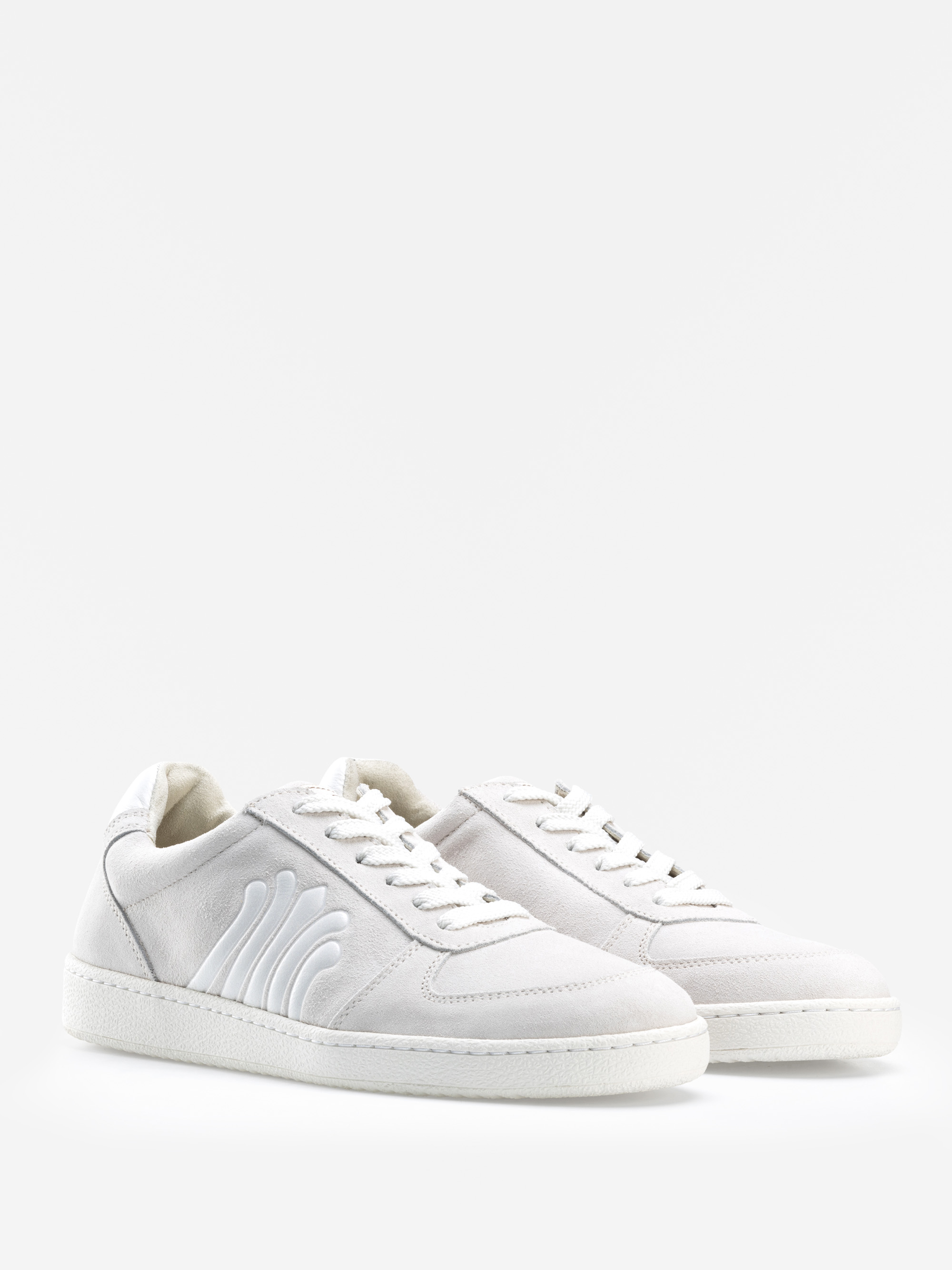 Ein Paar weiße Low-Top-Sneaker mit strukturierten Seitendetails und weißen Schnürsenkeln, die vor einem schlichten weißen Hintergrund stehen.