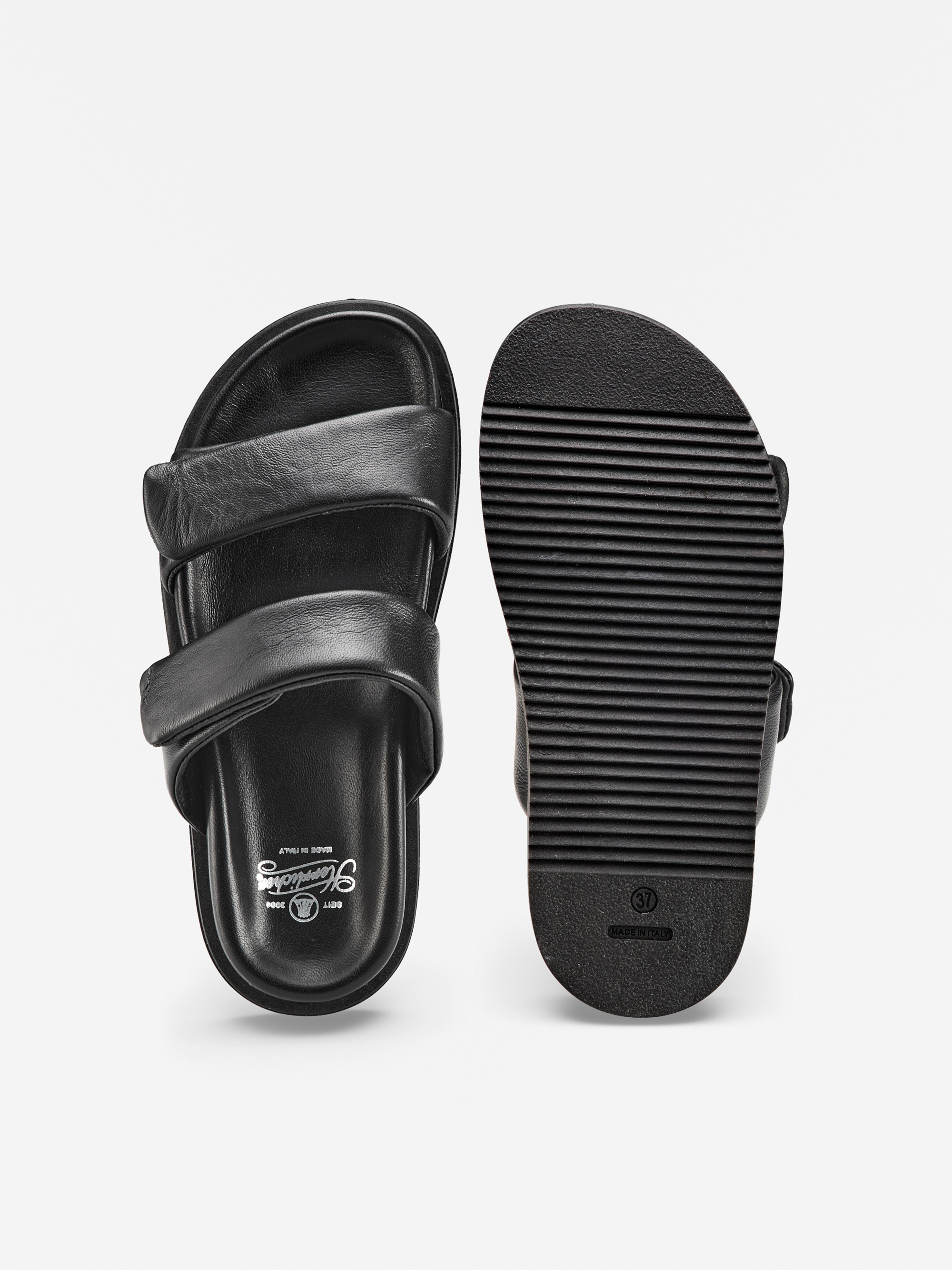 Ein Paar schwarze Gleitsandalen mit zwei Riemen, dargestellt von oben und unten auf weißem Hintergrund. Die obere Ansicht zeigt das Markenlogo im Inneren, und die Sohle hat horizontale Rillen für die Traktion.