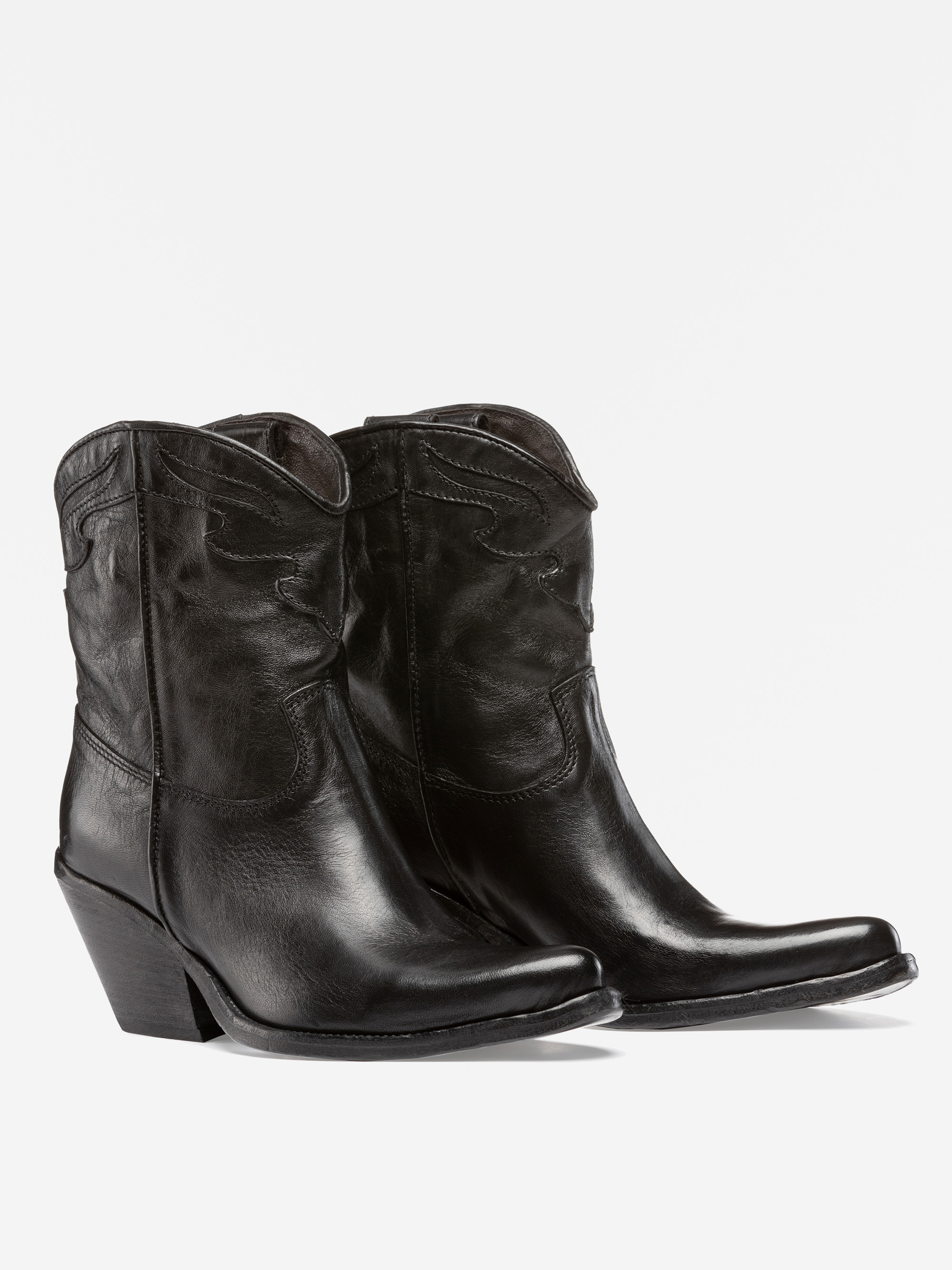 Ein Paar schwarzer Cowboystiefel aus Leder mit niedrigem, schrägem Absatz und Ziernähten, die nebeneinander auf einem schlichten weißen Hintergrund stehen.