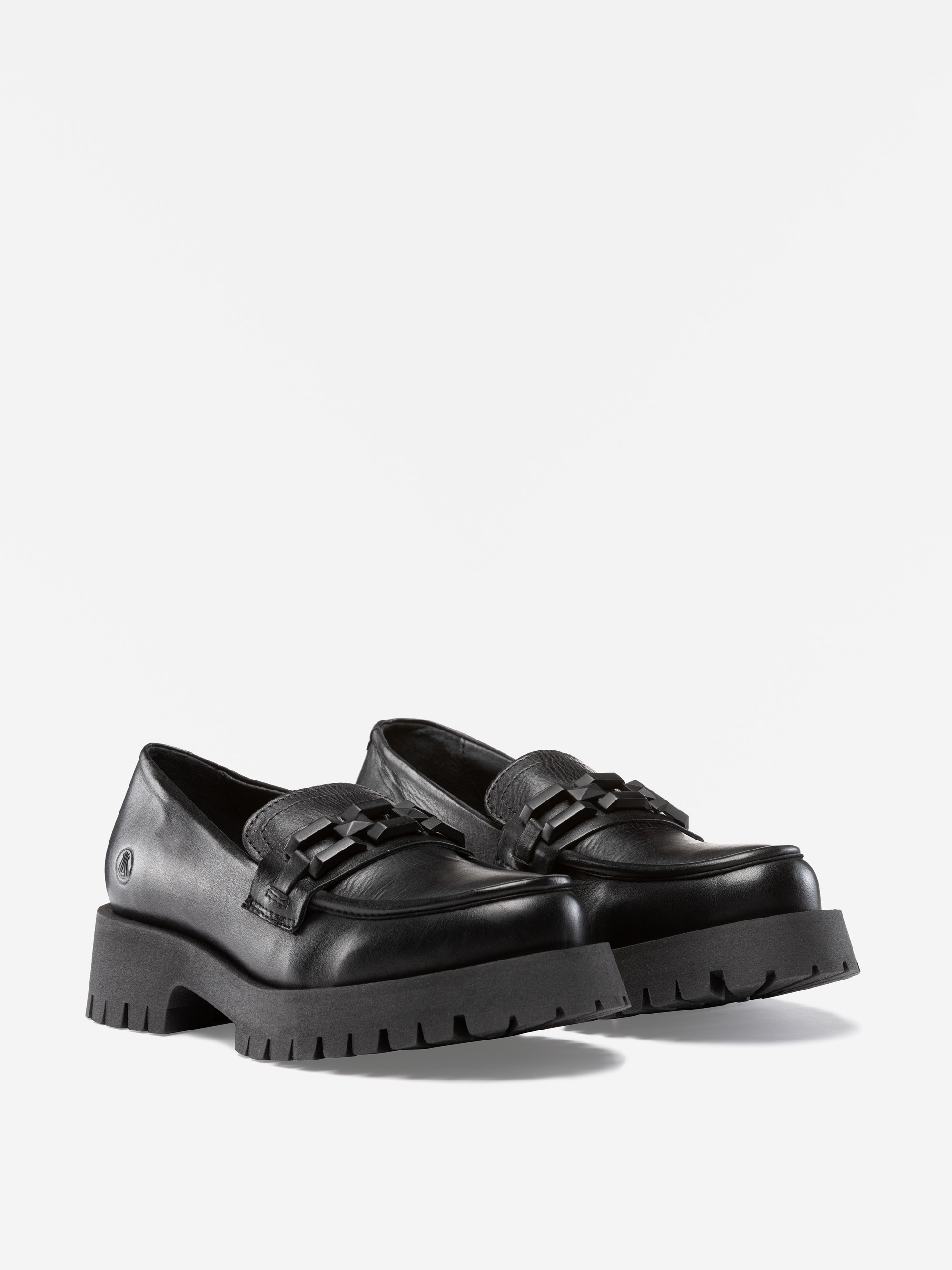 Ein Paar schwarze, klobige Plateau-Slipper mit dicken, robusten Sohlen, strukturiertem Obermaterial und dekorativen Kettendetails auf der Vorderseite, die vor einem schlichten weißen Hintergrund stehen.