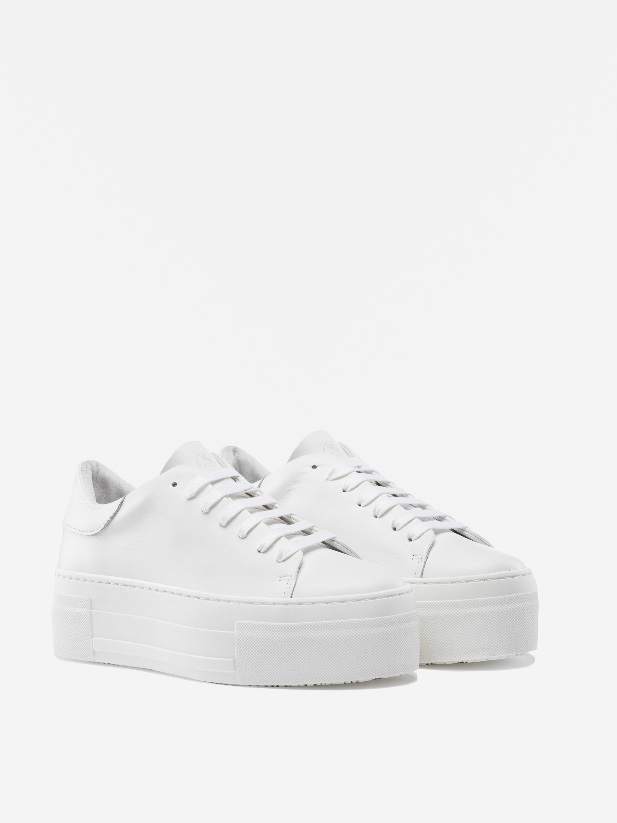 Ein Paar weißer Plateau-Sneakers mit dicken Sohlen und weißen Schnürsenkeln, dargestellt auf einem schlichten weißen Hintergrund.