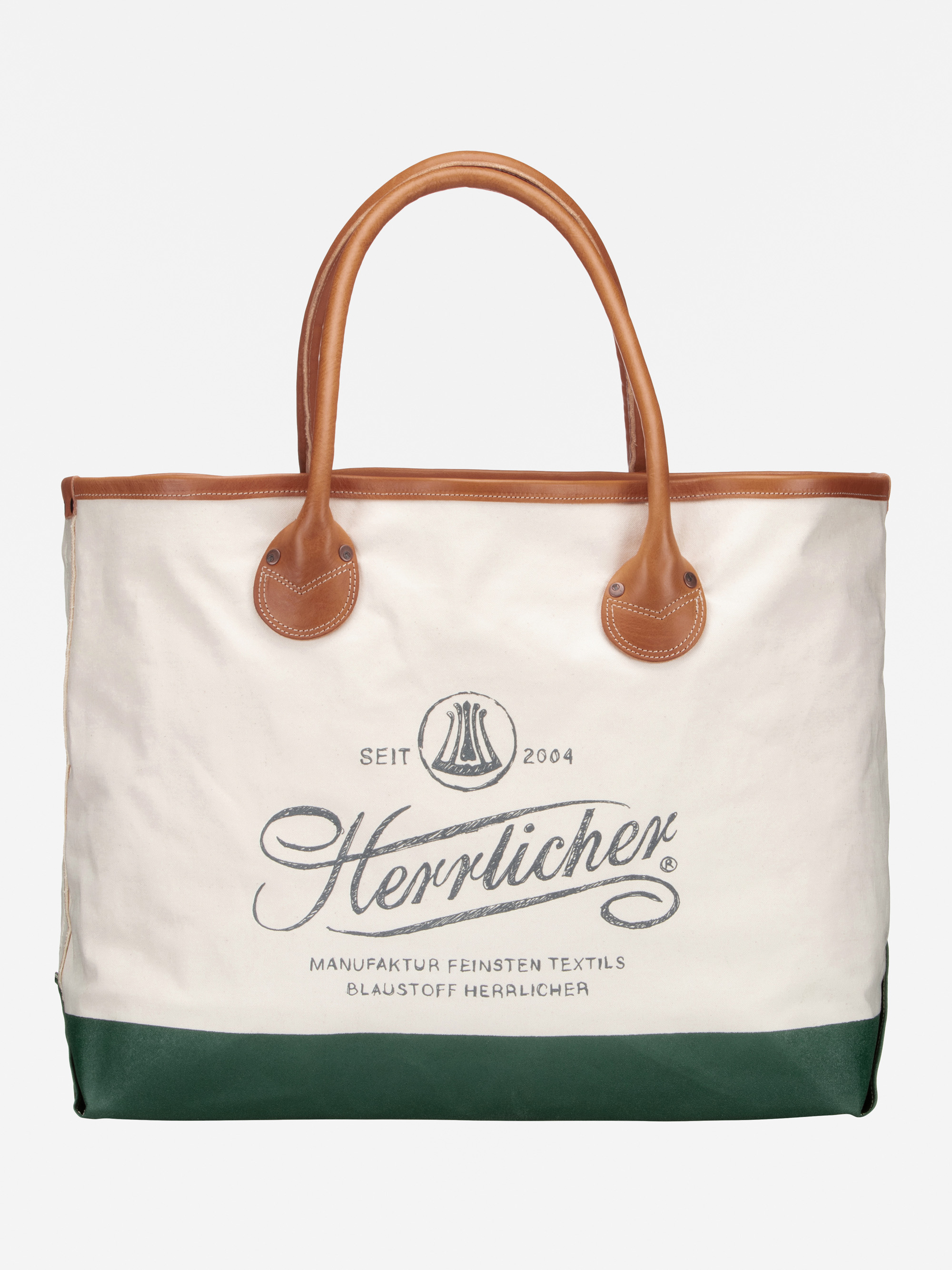 Eine Tragetasche aus Segeltuch mit braunen Ledergriffen, cremefarbener Oberseite, dunkelgrüner Unterseite und dem Herrlicher-Logo und -Text auf der Vorderseite.