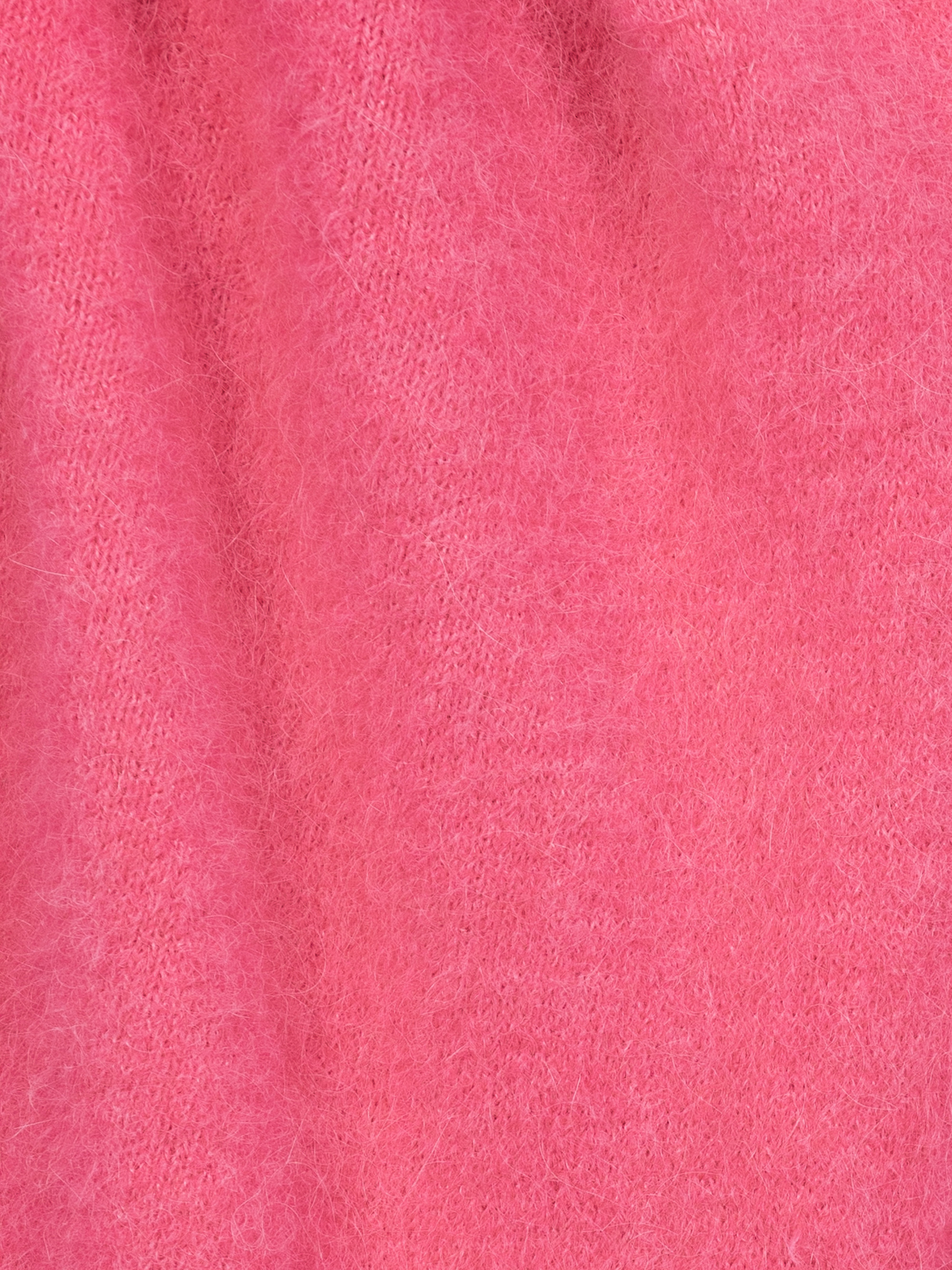 Nahaufnahme eines weichen, flauschigen rosafarbenen Stoffes mit leicht strukturierter Oberfläche und sichtbaren Fasern, die ein warmes und gemütliches Aussehen erzeugen.