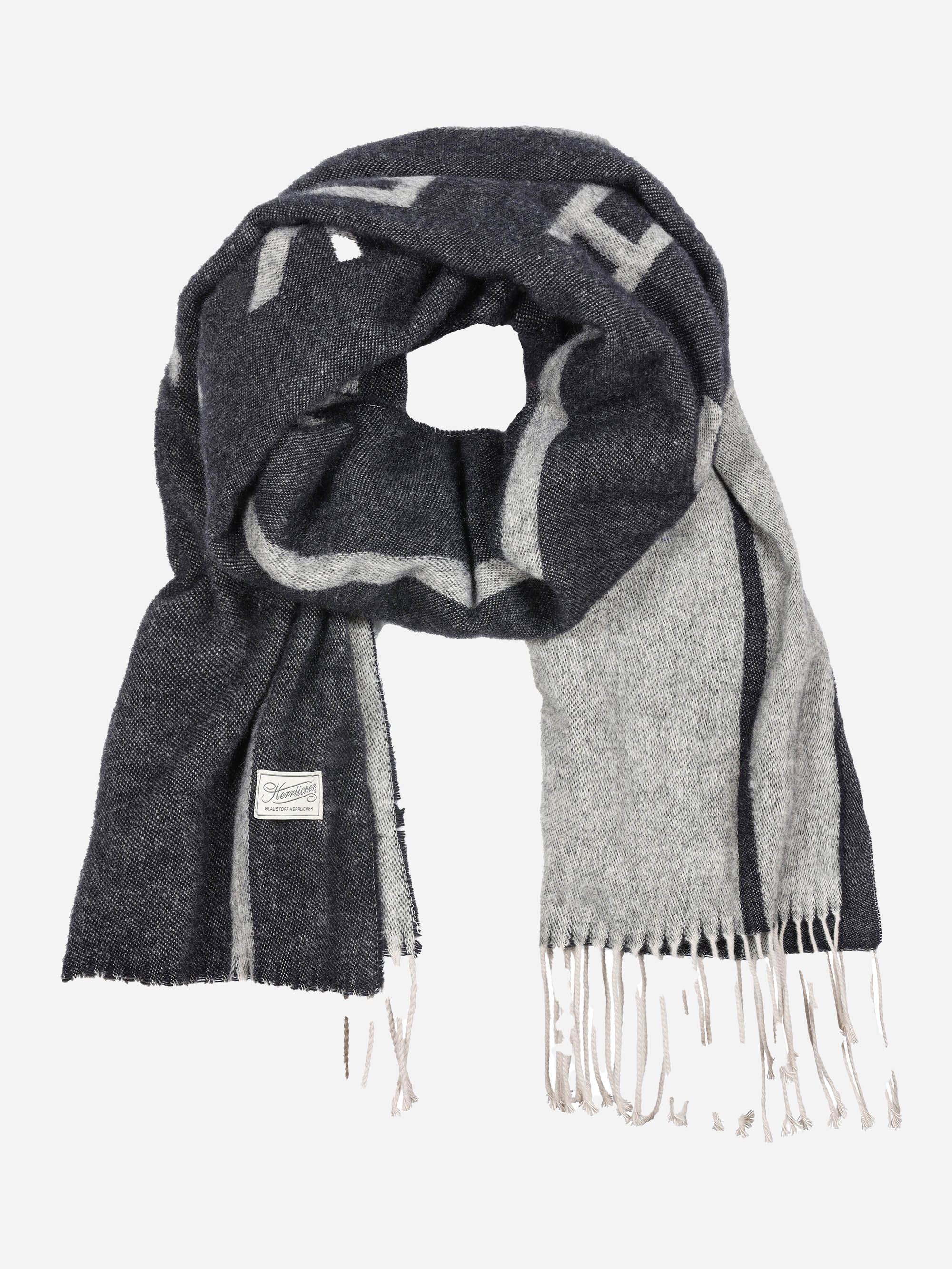 Ein Wollschal in Dunkelgrau und Hellgrau mit einem ausgefransten Rand und einem kleinen weißen Label-Patch. Der Schal ist gefaltet und in einer losen Schlaufe drapiert.