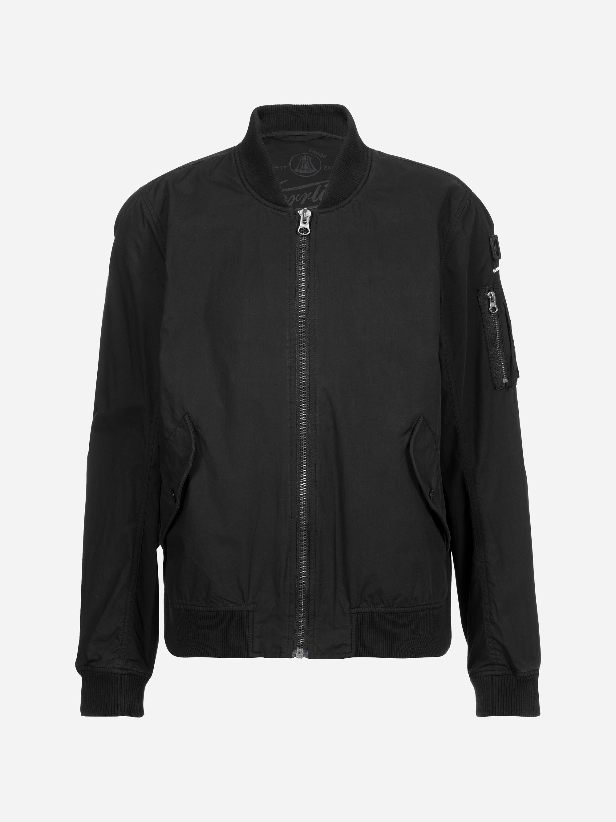 Eine schlichte schwarze Bomberjacke mit Frontreißverschluss, gerippten Bündchen und Saum, schrägen Seitentaschen und einer Reißverschlusstasche am linken Ärmel auf weißem Hintergrund.