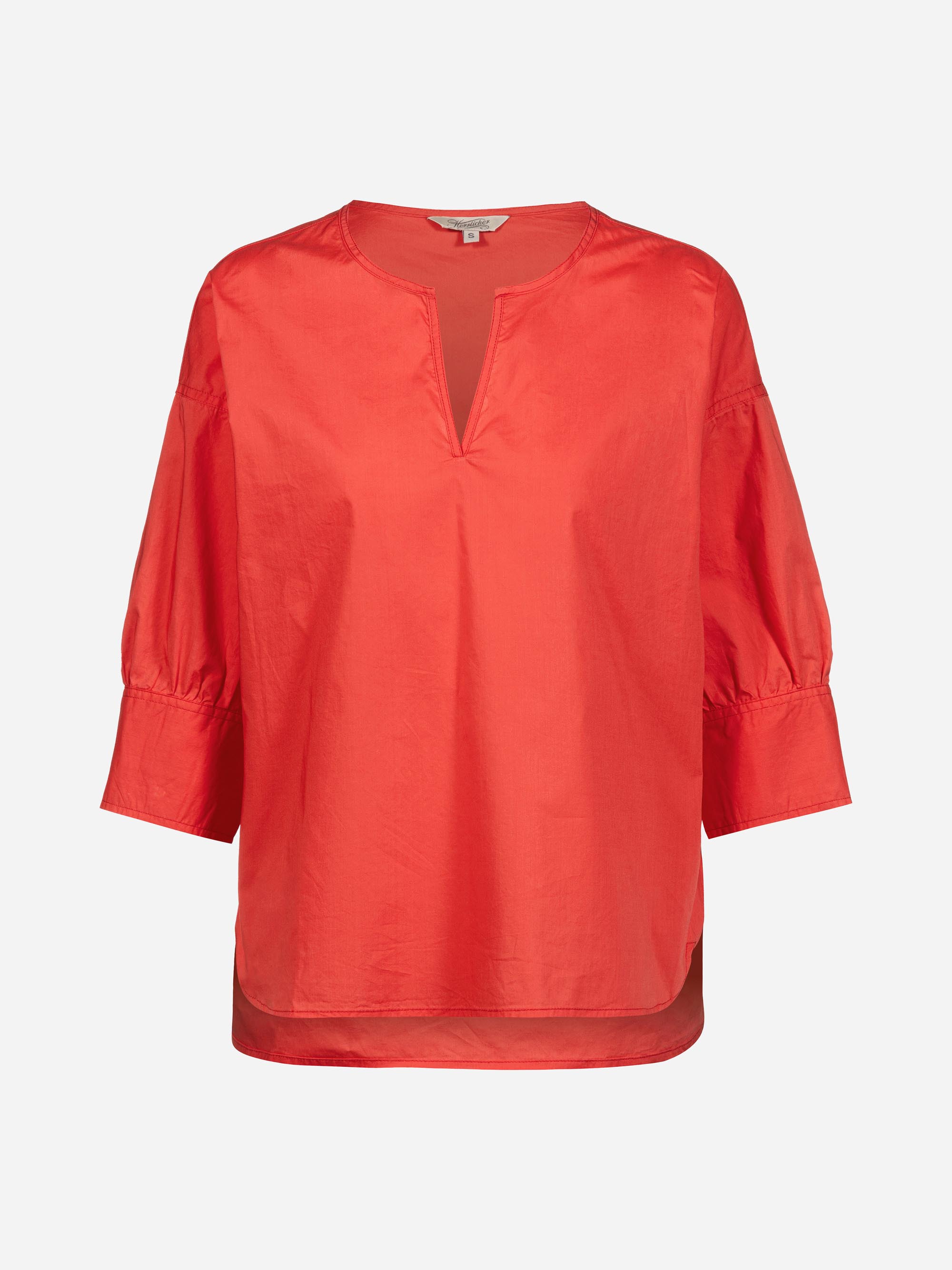 Eine locker sitzende, leuchtend rote Bluse mit Dreiviertel-Ärmeln, geschlitztem V-Ausschnitt und hinten etwas längerem Saum auf einfarbig weißem Grund.