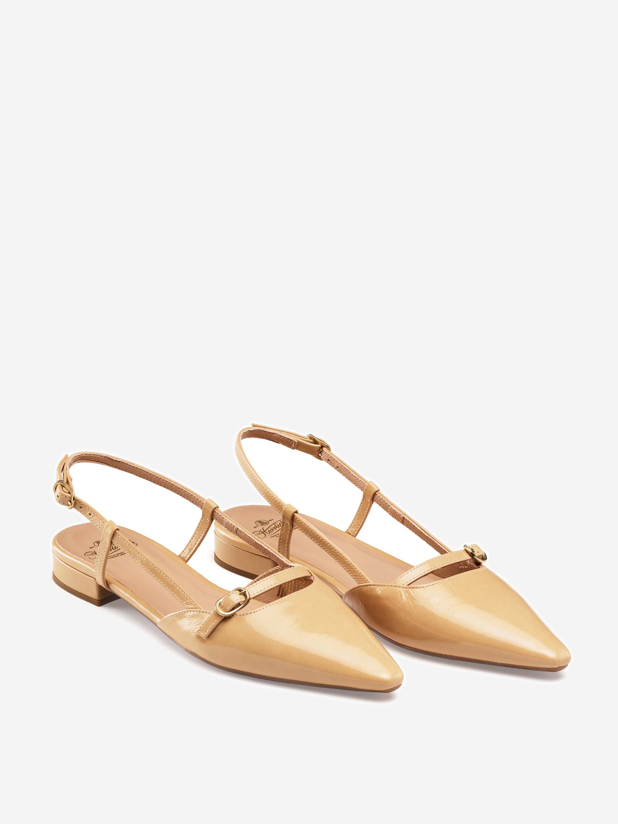 Ein Paar glänzender beiger Slingback-Flats mit spitzen Zehen, niedrigem Blockabsatz und einem dünnen Riemen auf der Vorderseite, mit goldenen Schnallendetails und verstellbaren Knöchelriemen auf weißem Hintergrund.