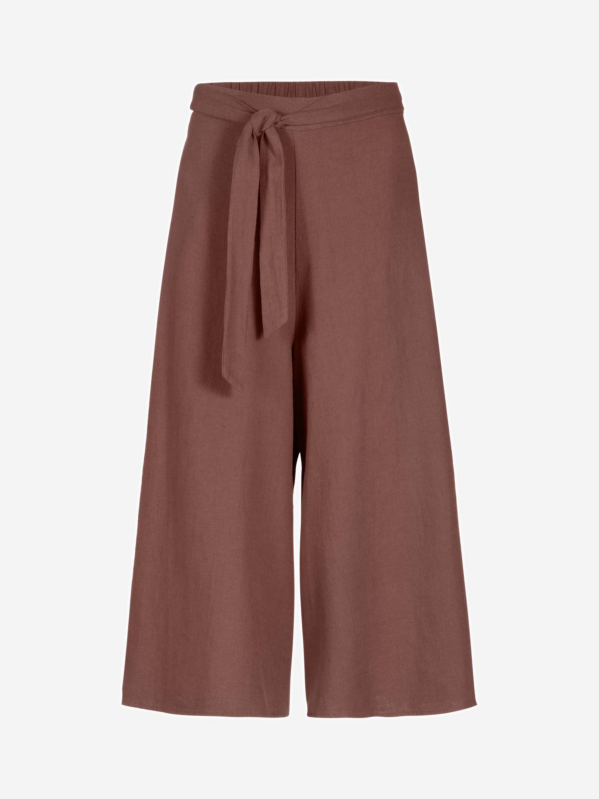 Weite, hochtaillierte braune Culotte-Hosen mit einem passenden Stoffgürtel, der in der Taille gebunden wird, vor einem schlichten hellen Hintergrund.