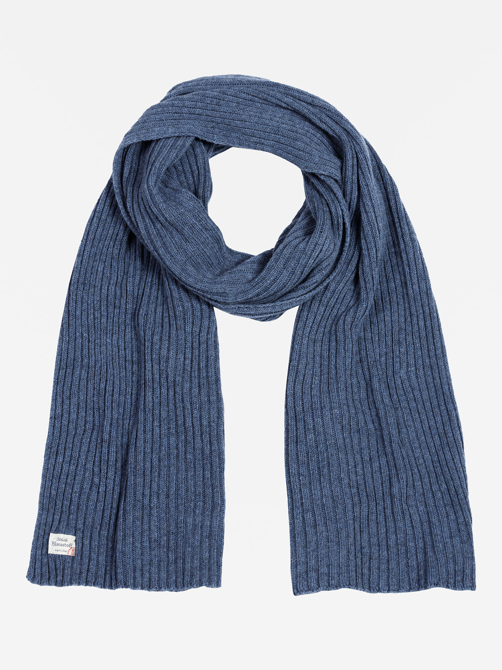Ein langer, gerippter blauer Strickschal liegt flach auf einem weißen Hintergrund. An einem Ende des Schals ist ein kleines rechteckiges weißes Etikett mit Text und einem winzigen Flaggenmuster angenäht.
