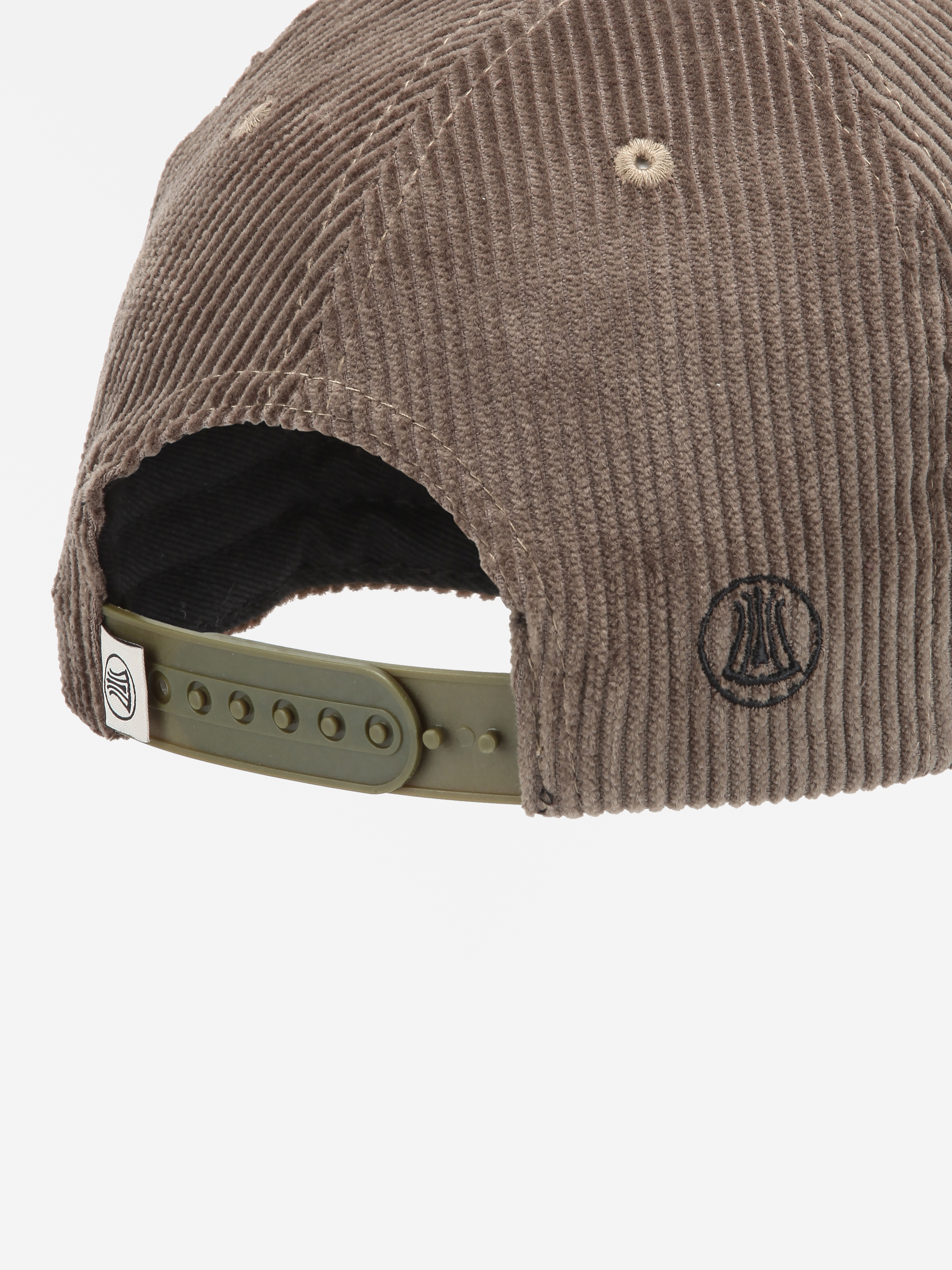 Nahaufnahme der Rückseite einer braunen Cordmütze mit einem verstellbaren grünen Snapback-Riemen und einem kleinen schwarzen gestickten Logo auf der rechten Seite.