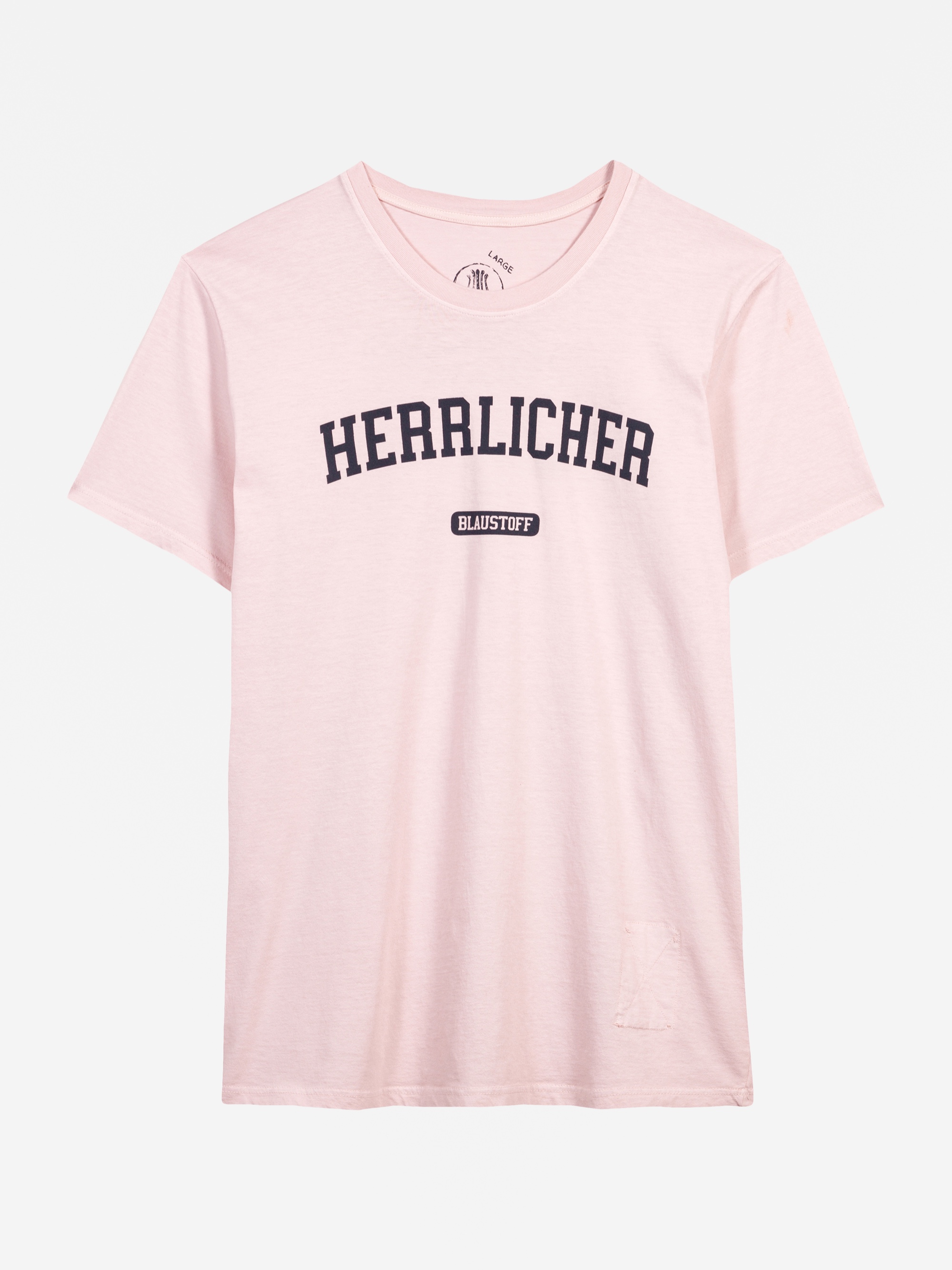Hellrosa Kurzarm-T-Shirt mit dem Wort HERRLICHER in großen, fetten schwarzen Buchstaben quer über der Brust und einem kleinen BLAUSTOFF-Label darunter. Das Shirt ist auf einem weißen Hintergrund abgebildet.
