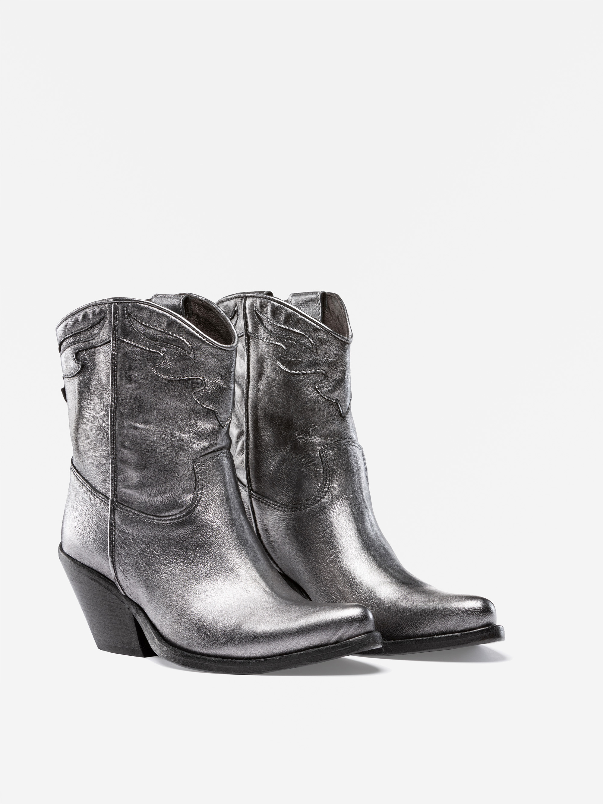 Ein Paar schwarzer, glänzender Cowboystiefel aus Leder mit spitzen Zehen, Ziernähten und abgewinkelten Absätzen, dargestellt auf einem schlichten weißen Hintergrund.