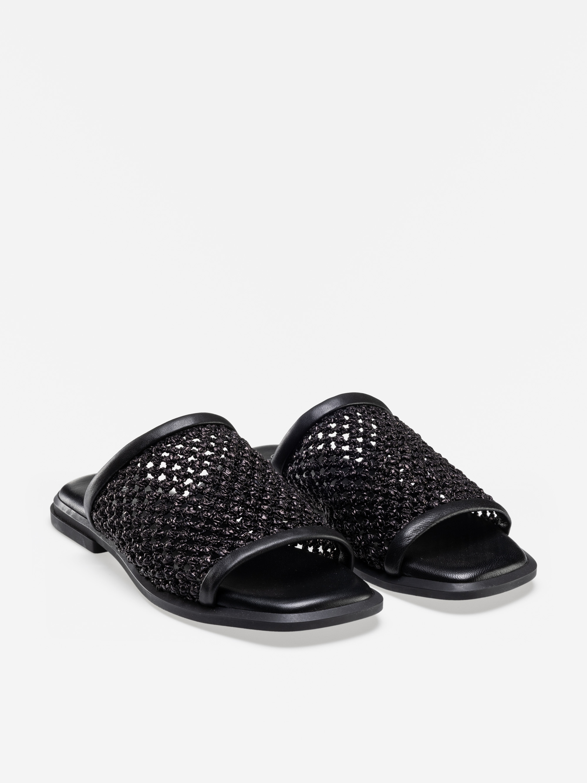 Ein Paar schwarzer, zehenoffener Slide-Sandalen mit gewebtem, strukturiertem Obermaterial und flacher Sohle, die auf einem schlichten weißen Hintergrund abgebildet sind.