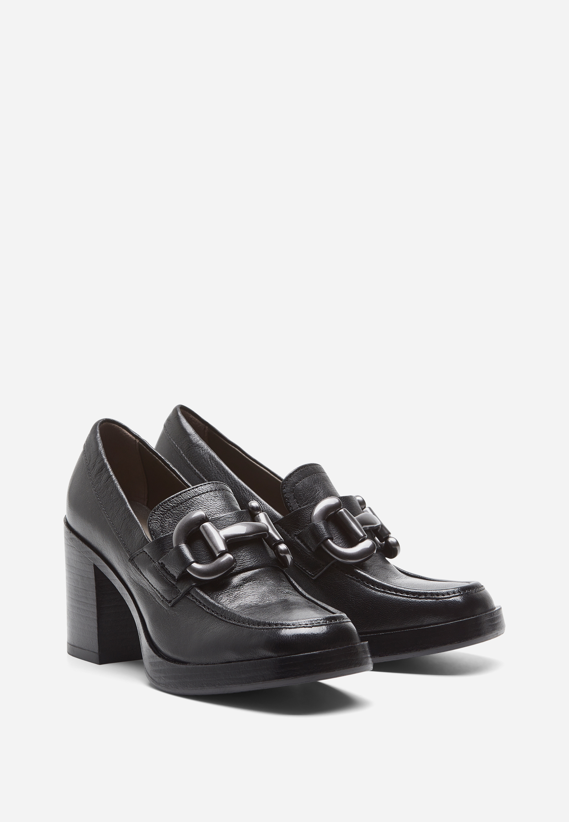 Ein Paar schwarzer Slipper mit hohem Blockabsatz und großen Zierschnallen auf der Vorderseite, die auf einem schlichten weißen Hintergrund stehen.