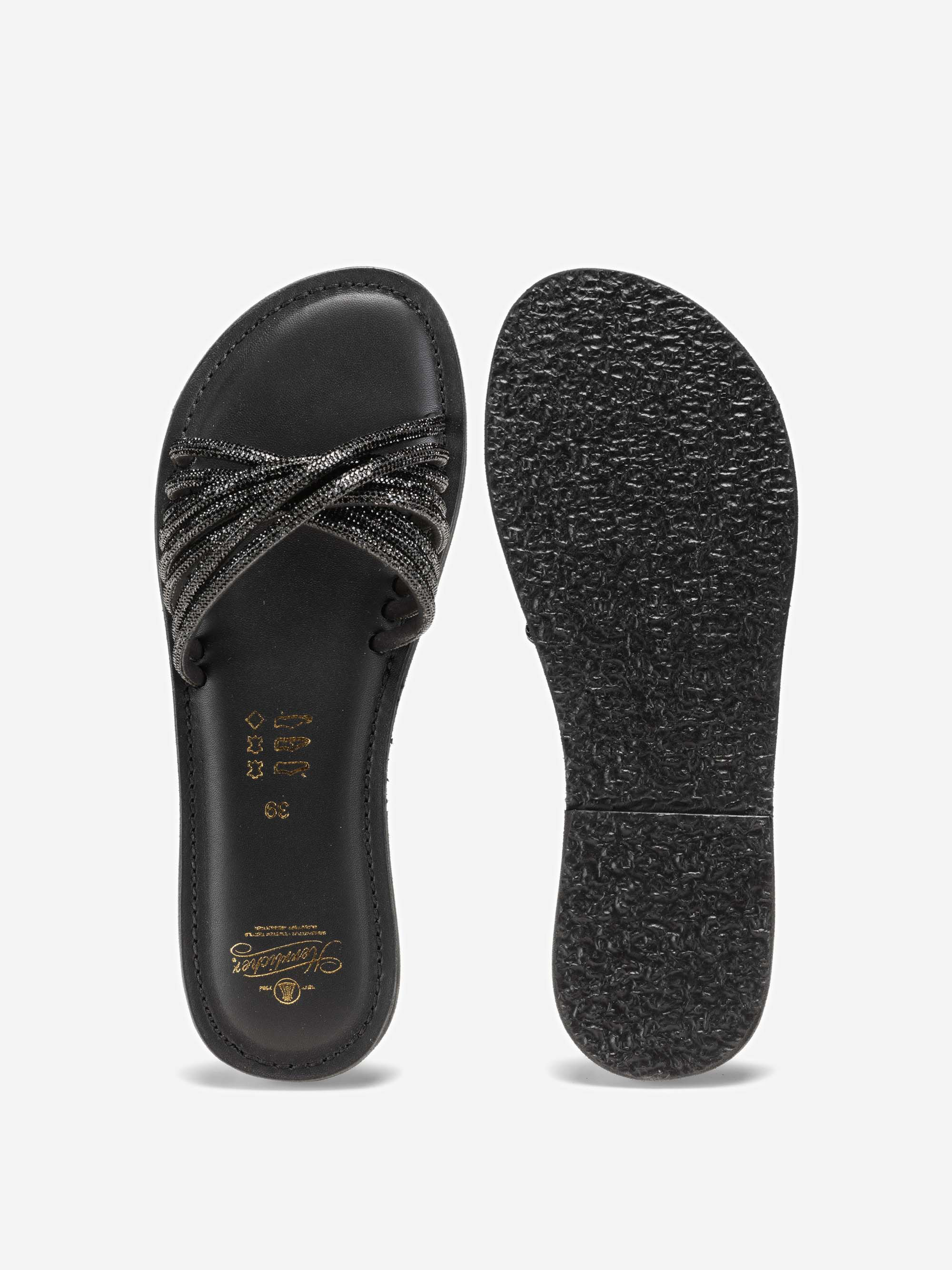 Ein Paar schwarze Slipper mit überkreuzten Riemen und metallischen Akzenten. Die eine Sandale ist von oben und die andere von unten abgebildet, wobei die strukturierte Sohle und das goldene Branding auf der Innensohle zu sehen sind.