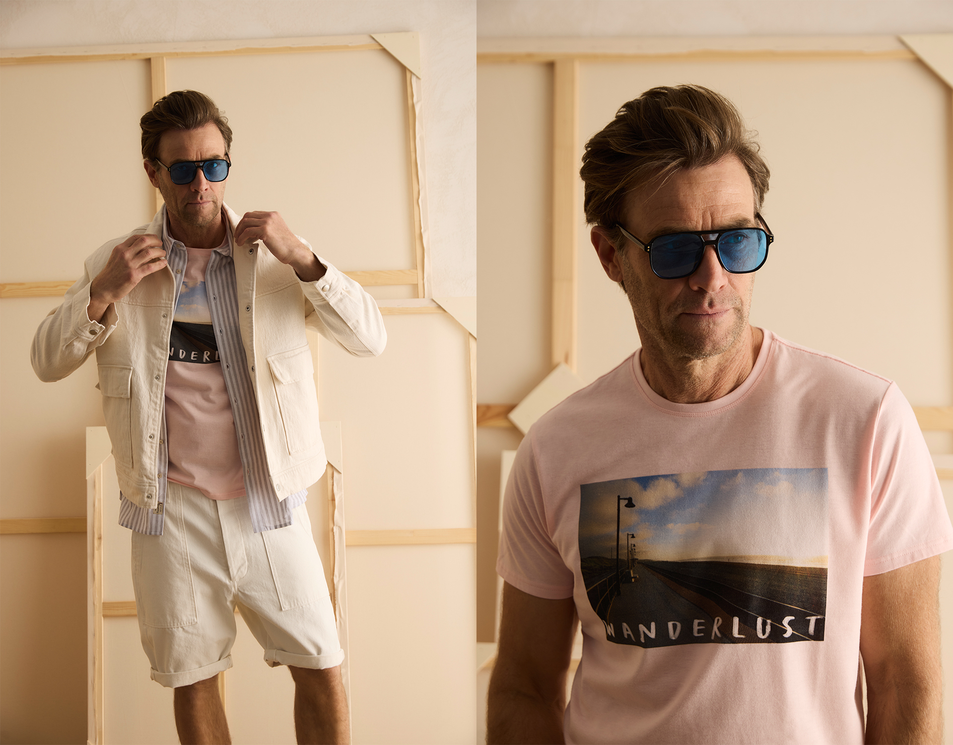 Ein Mann, der eine blaue Sonnenbrille, ein hellrosa Wanderlust-T-Shirt mit einem Landschaftsfoto, weiße Shorts und eine cremefarbene Jacke trägt und in einem Haus vor einem hellen Hintergrund posiert.