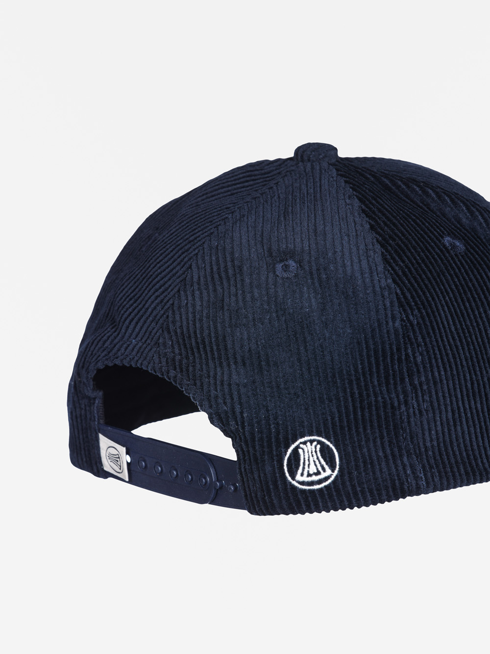 Die Baseballkappe aus marineblauem Cord zeigt sich von hinten und ist mit einem weißen gestickten Logo und einem verstellbaren Snapback-Riemen versehen.
