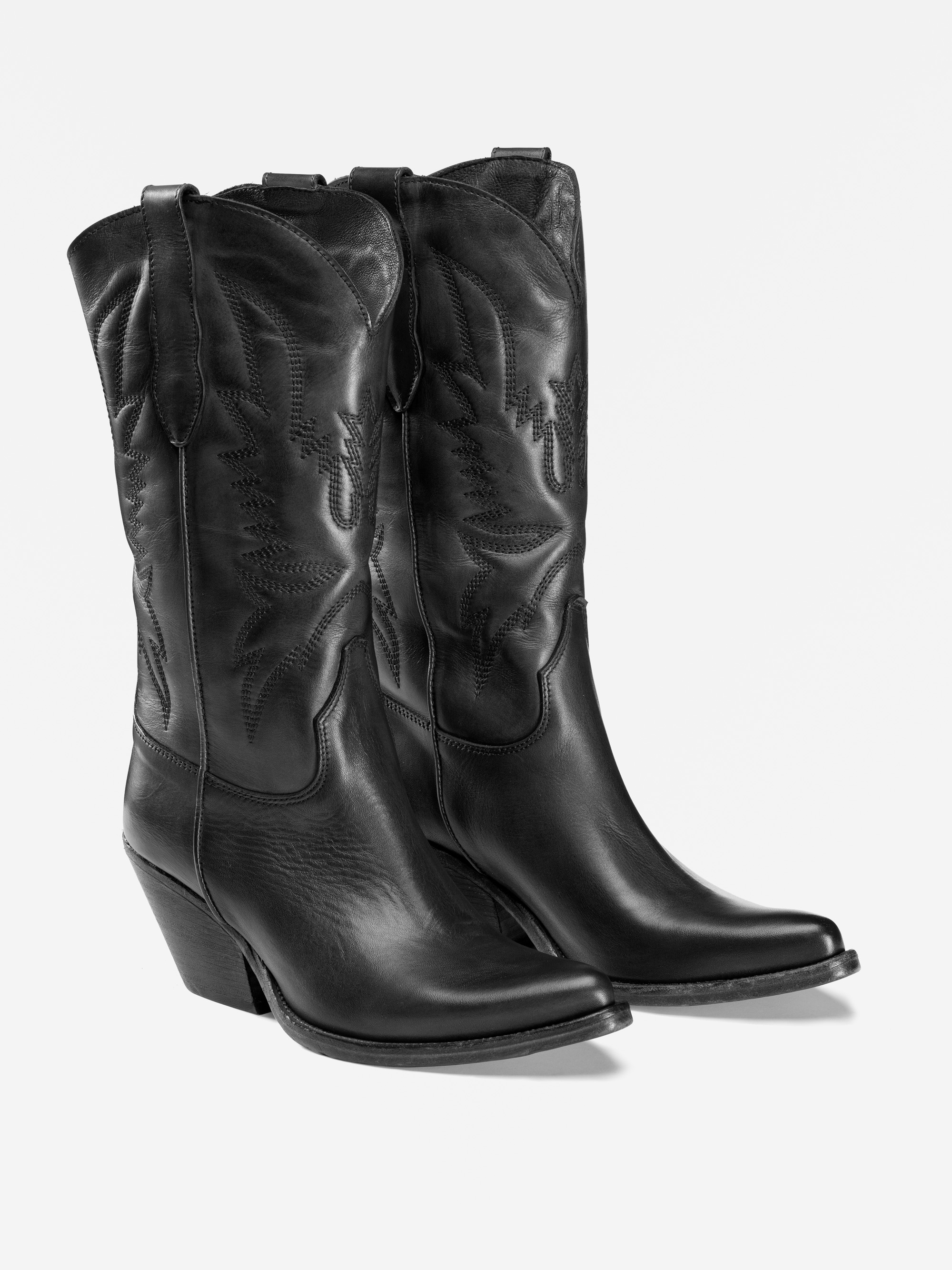 Ein Paar schwarze Cowboystiefel aus Leder mit Ziernähten, spitzen Zehen und abgewinkelten Absätzen, die nebeneinander auf einem weißen Hintergrund stehen.