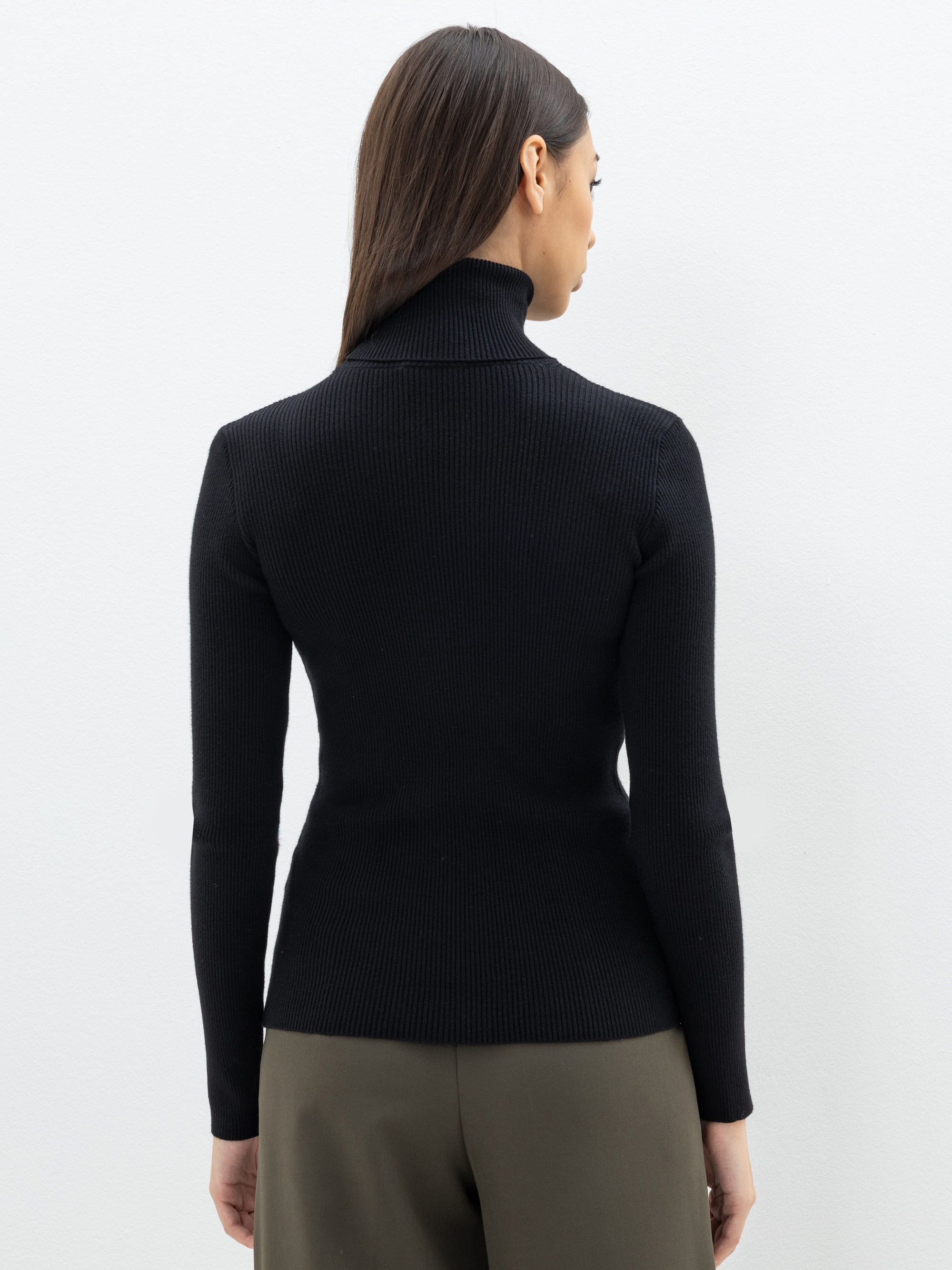 Eine Frau mit einem schwarzen Rollkragenpullover.