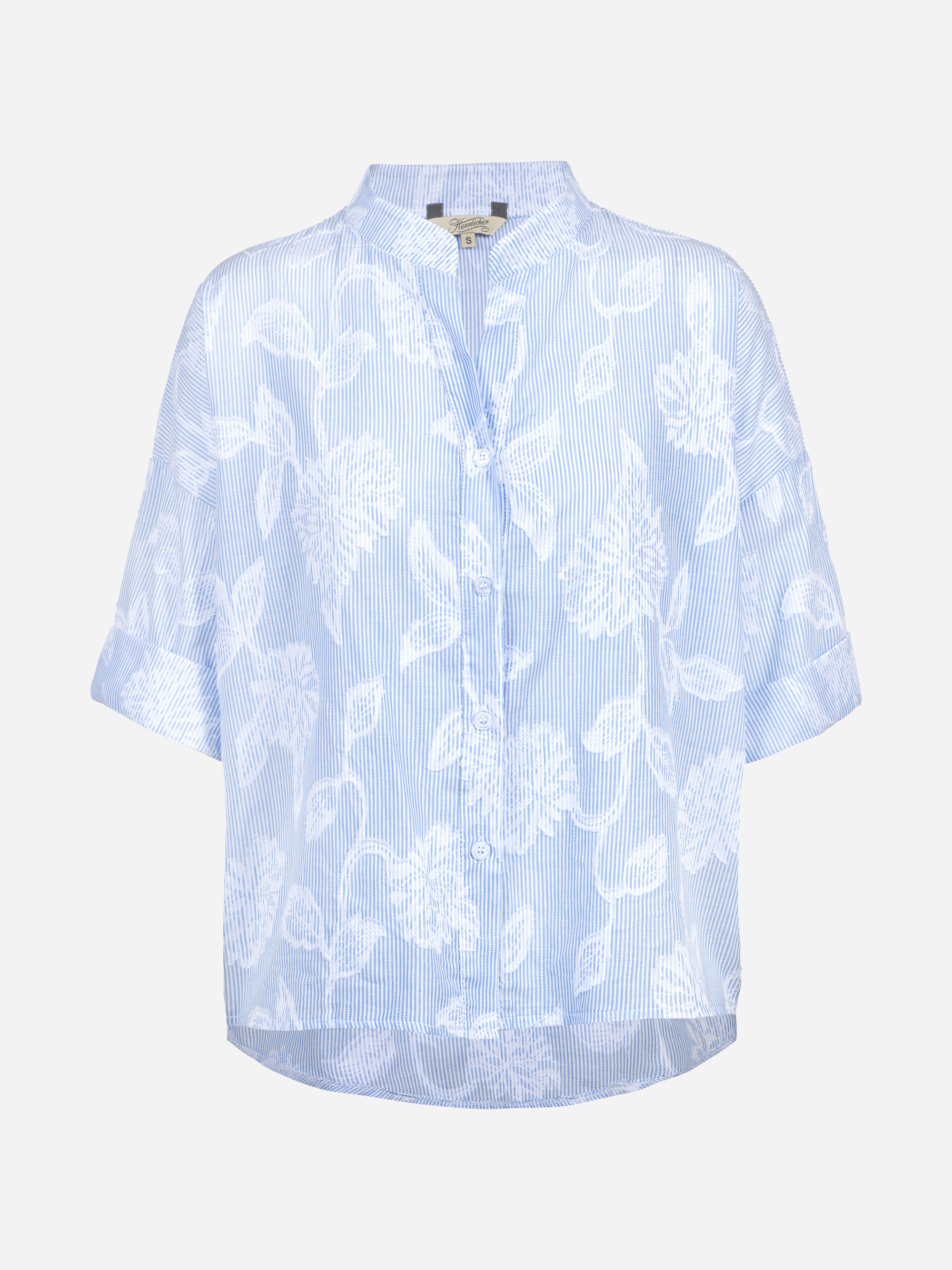 Hellblaue, kurzärmelige Bluse mit dezentem weißem Blumenmuster, Knopfleiste und Stehkragen auf weißem Grund.