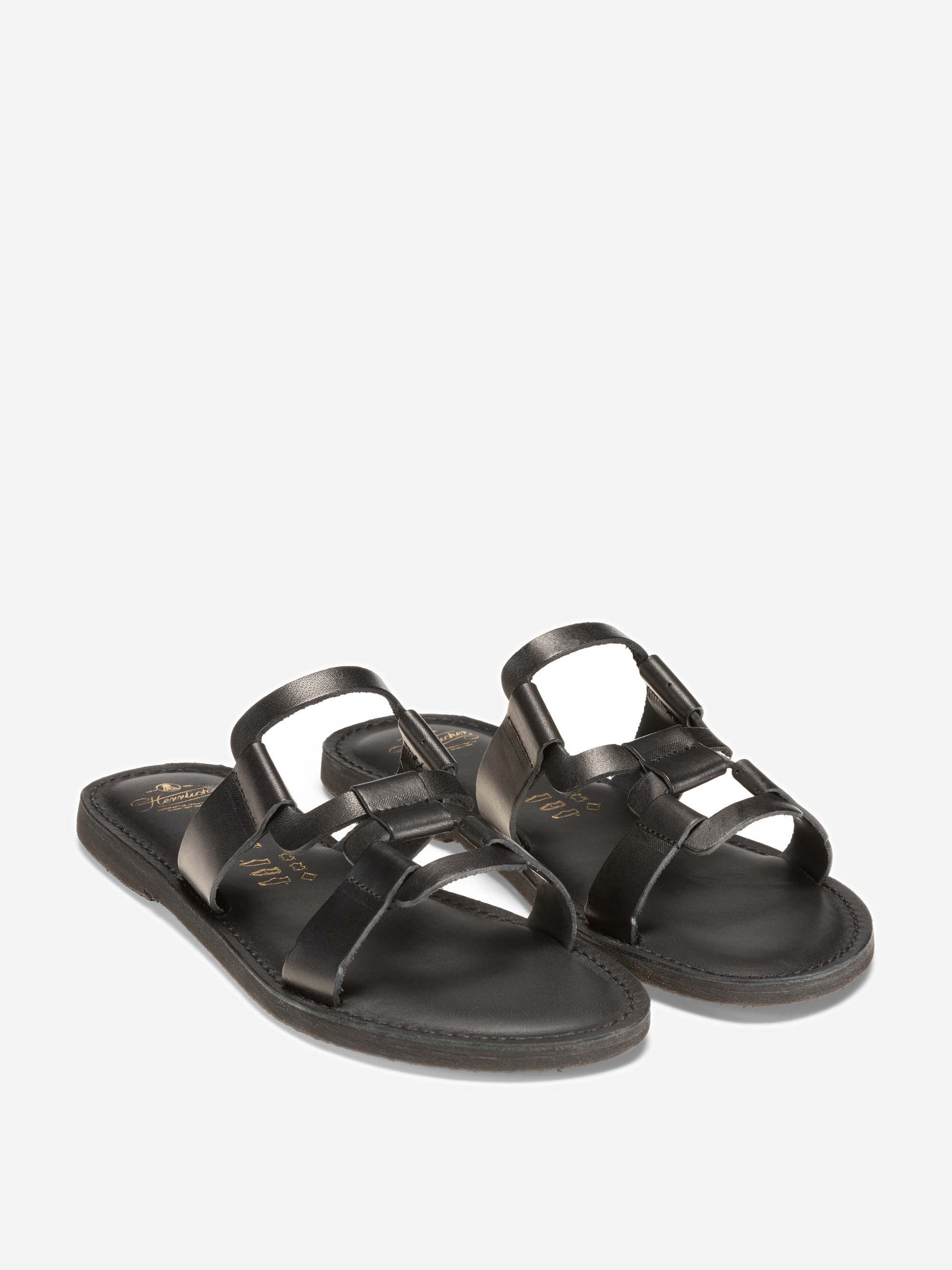 Ein Paar schwarzer Ledersandalen mit offenen Zehen und verflochtenen Riemen, dargestellt auf einem schlichten weißen Hintergrund.