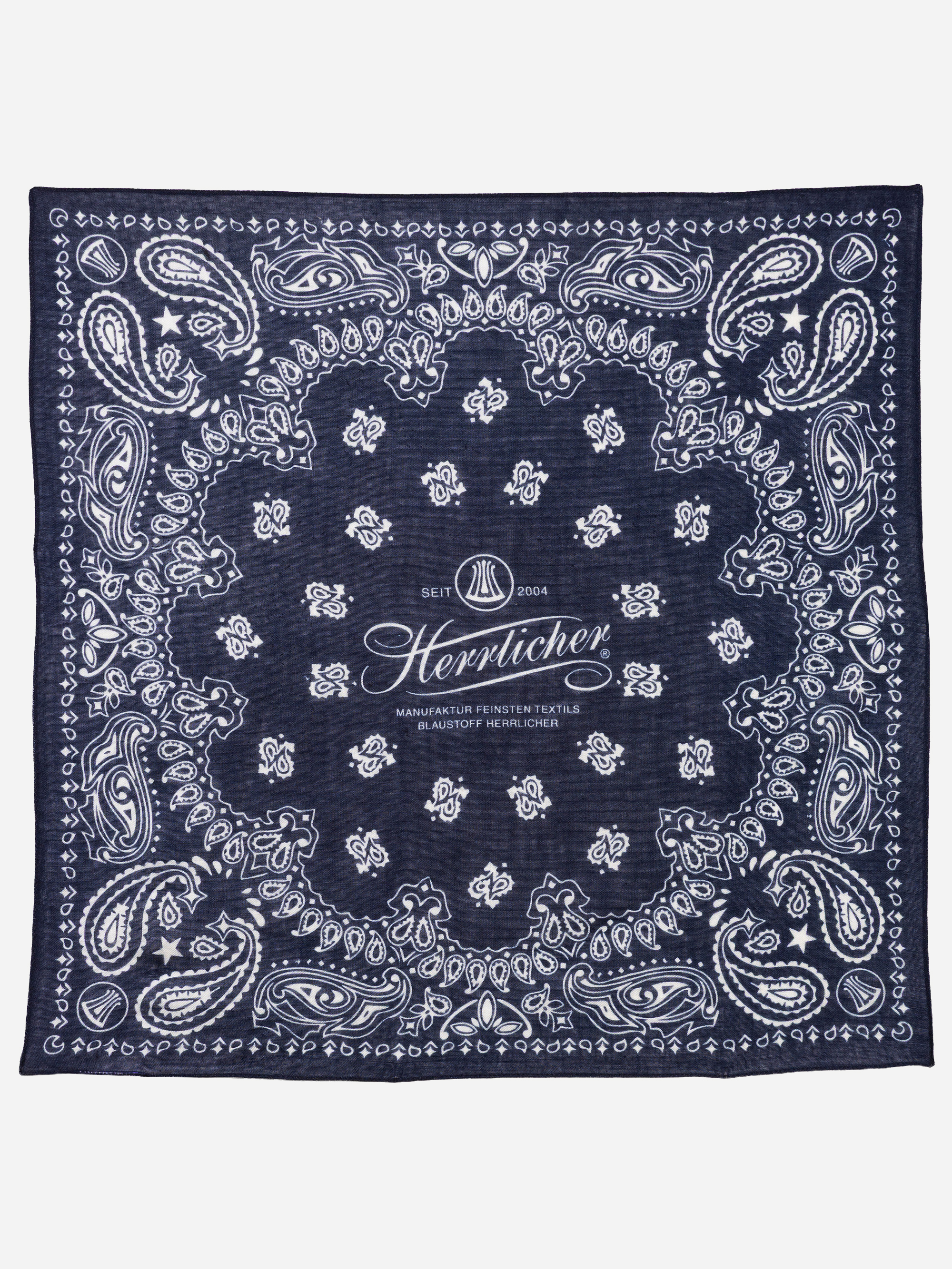 Marineblaues Bandana mit weißem Paisley-Muster und verziertem Rand. In der Mitte befinden sich ein dekorativer Schriftzug und ein Logo mit der Aufschrift „Seit 2004 Herrlicher Manufaktur Feinster Textilien“.