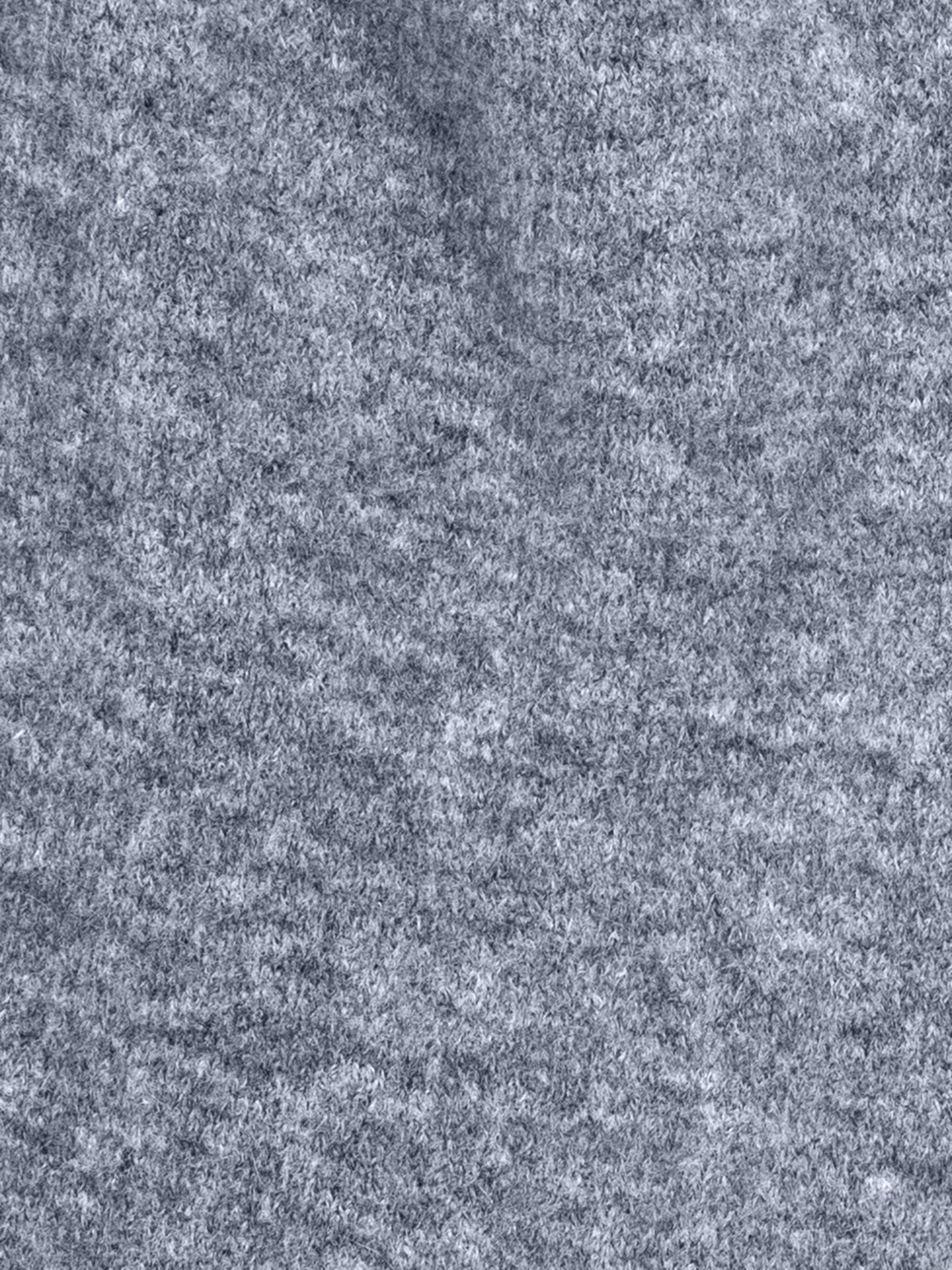 Nahaufnahme einer grauen, strukturierten Stoffoberfläche, die ein weiches und flauschiges Material mit einem leicht gesprenkelten Aussehen zeigt.