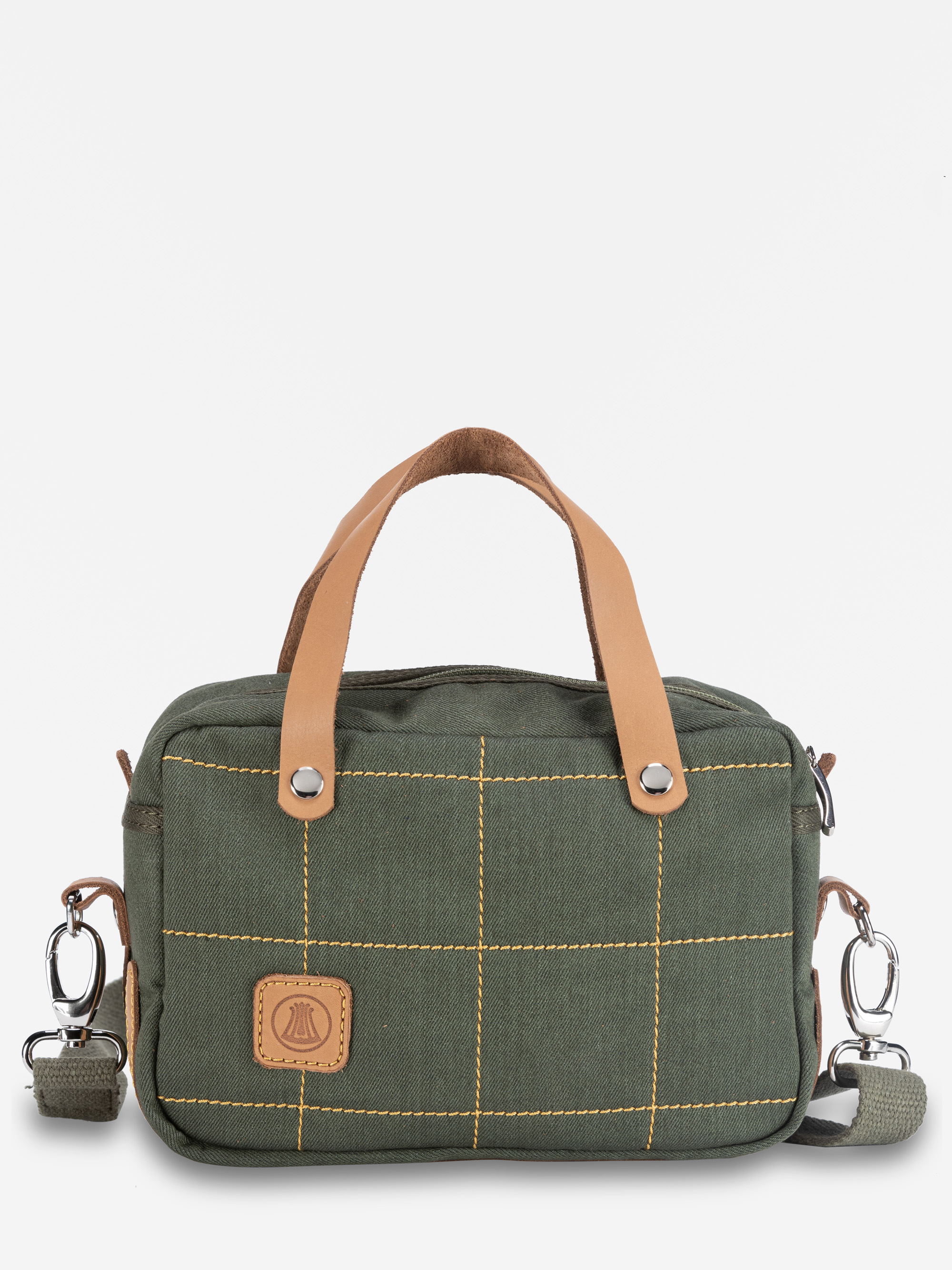 Eine kleine olivgrüne Handtasche aus Segeltuch mit hellbraunen Ledergriffen, gelben Gitternähten, einer Vordertasche, einem Logoaufnäher und abnehmbaren Schulterriemen mit silbernen Verschlüssen, dargestellt vor einem schlichten weißen Hintergrund.