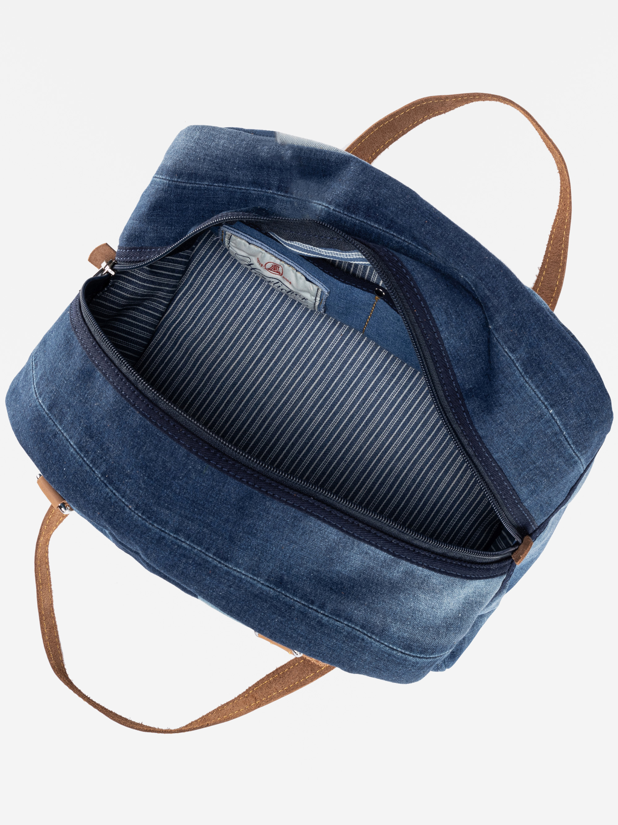 Eine Tasche aus blauem Denim mit braunen Henkeln, die von oben mit geöffnetem Reißverschluss gezeigt wird und ein grau-weiß gestreiftes Stofffutter sowie eine Innentasche offenbart.