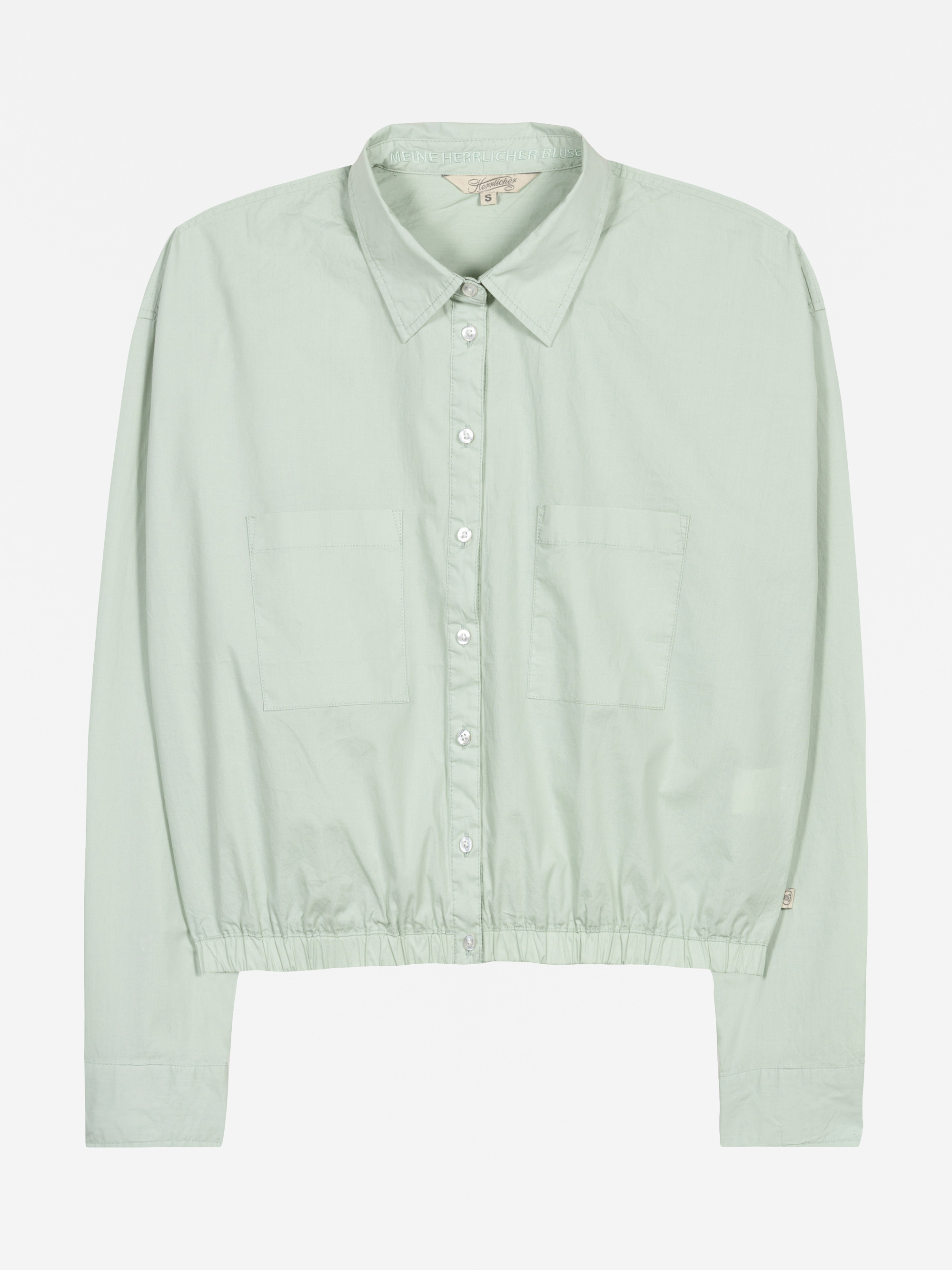Hellgrünes, langärmeliges Button-up-Hemd mit Kragen, zwei Brusttaschen vorne und elastischem Saum. Das Hemd hat eine lockere Passform und ist flach vor einem weißen Hintergrund abgebildet.