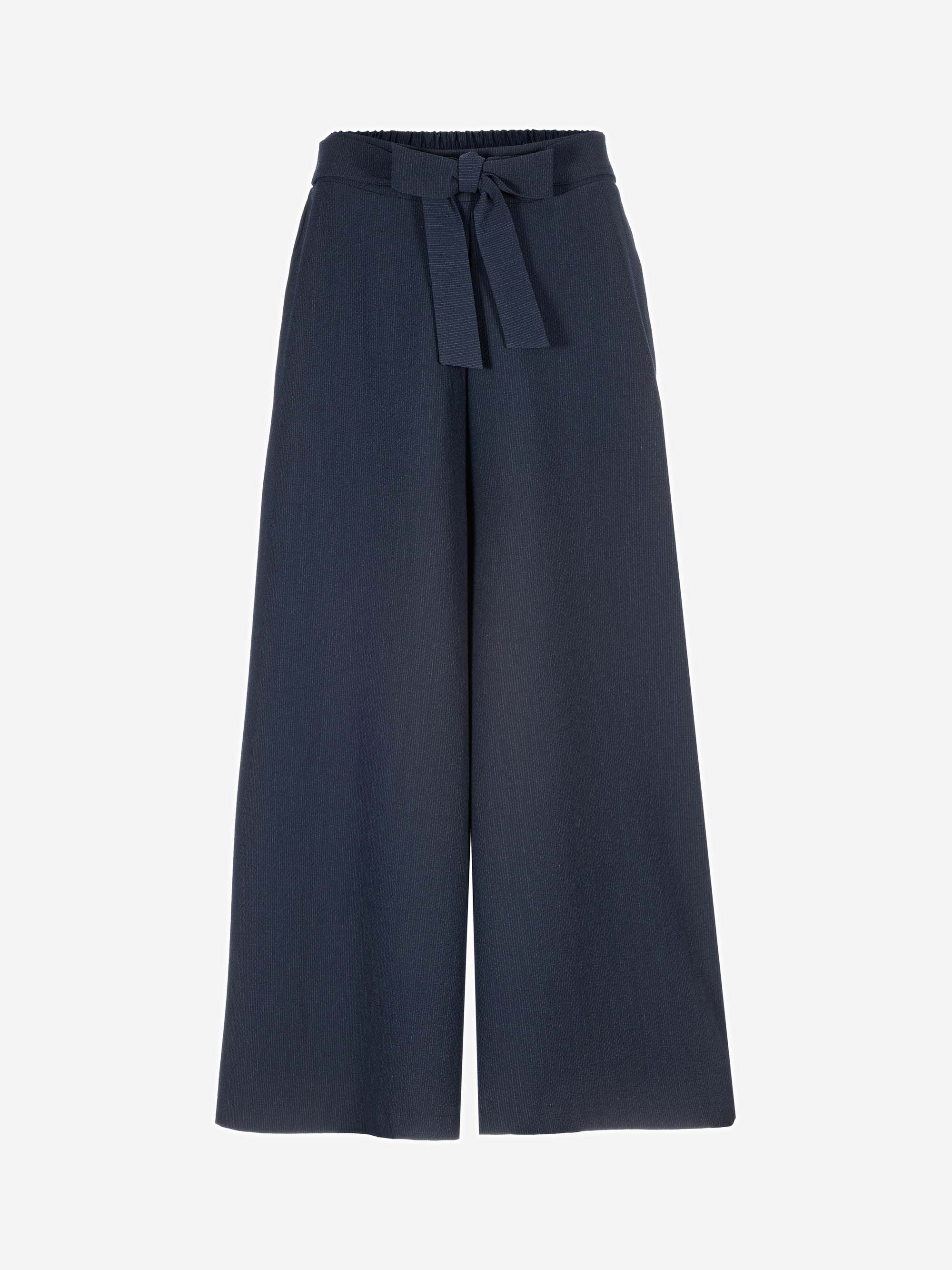 Marineblaue Hose mit weitem Bein und hoher Taille, mit Stoffgürtel und elastischem Bund, auf weißem Hintergrund.
