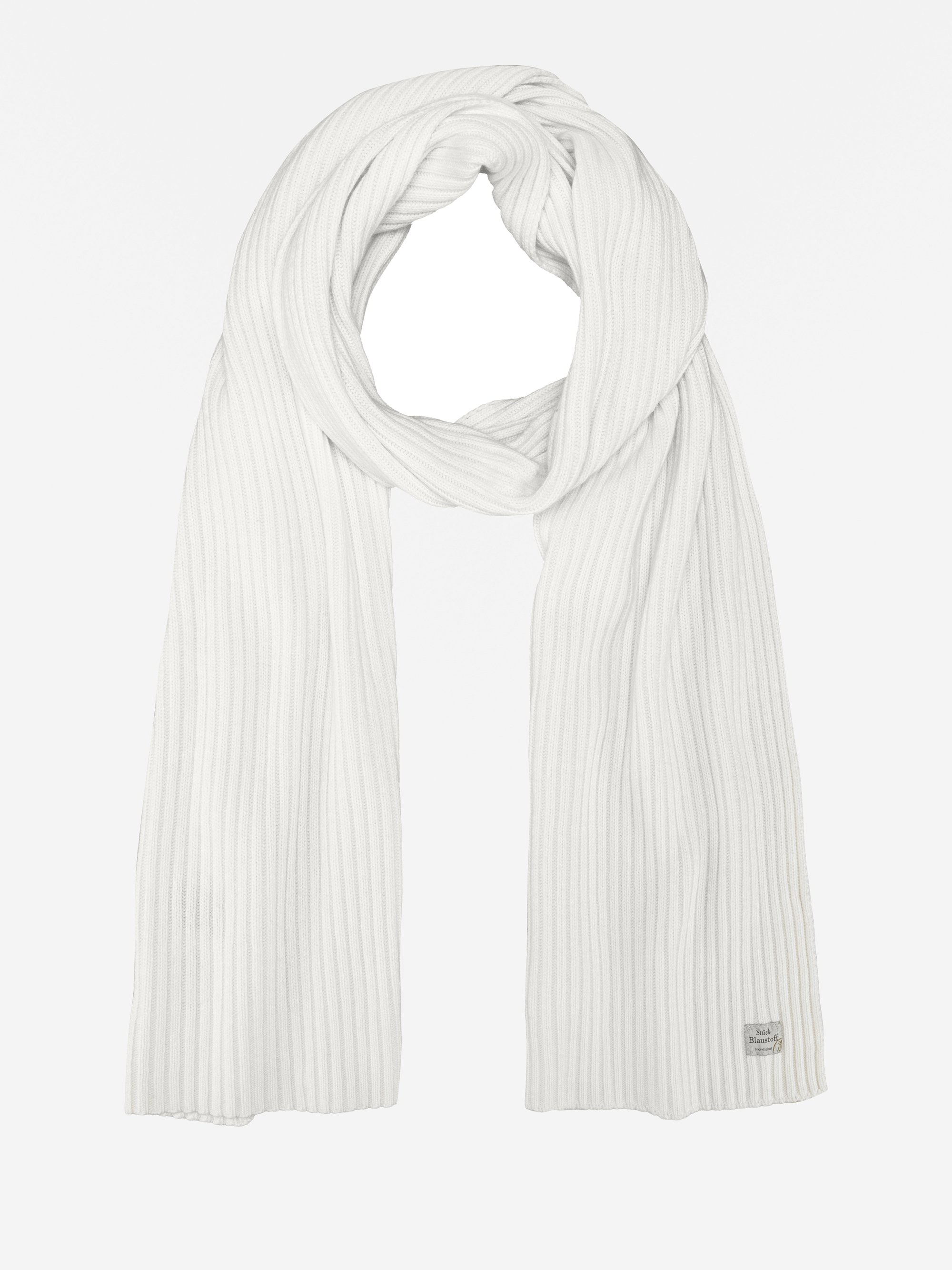 Ein langer, gerippter weißer Schal, der flach auf weißem Grund liegt und an einem Ende ein kleines rechteckiges Etikett aufweist.