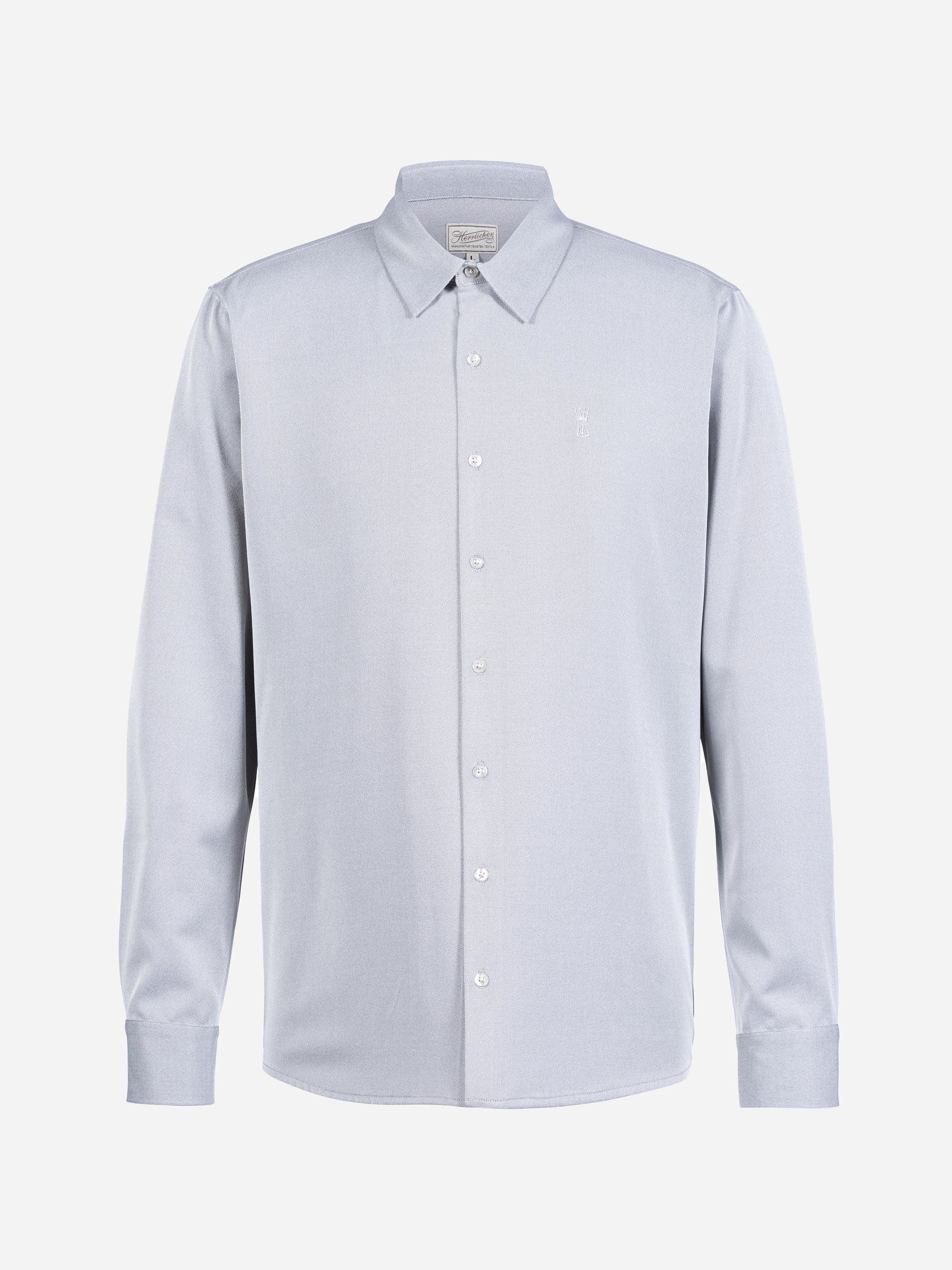 Ein hellgraues, langärmeliges Button-up-Hemd mit spitzem Kragen und weißen Knöpfen auf einem schlichten weißen Hintergrund.