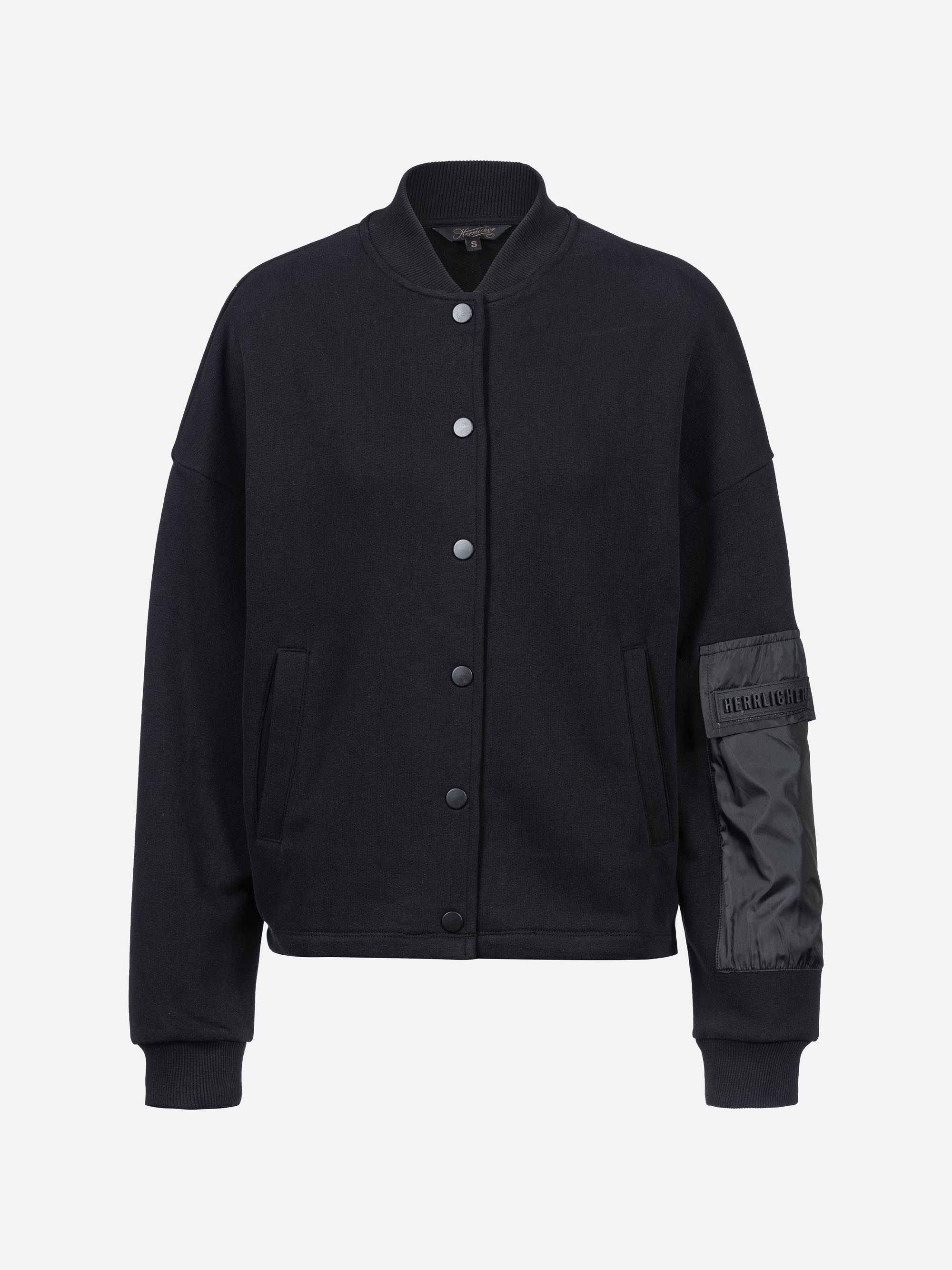 Schwarze, geknöpfte Bomberjacke mit geripptem Kragen, Manschetten und Saum, Vordertaschen und einer glänzenden Reißverschlusstasche am linken Ärmel auf weißem Grund.