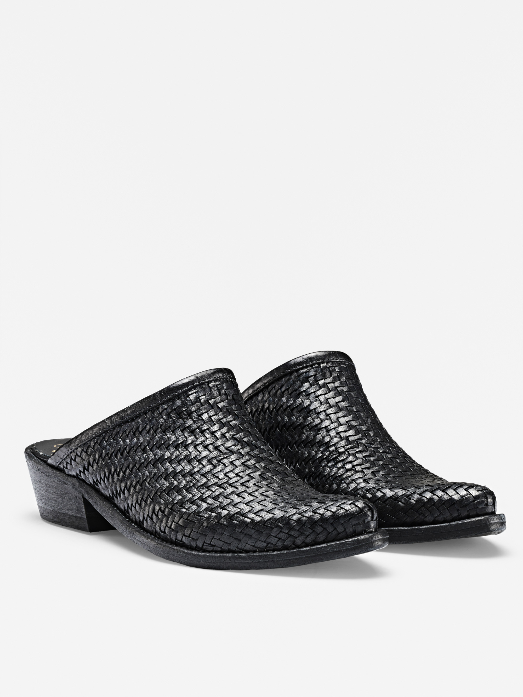 Ein Paar schwarzer Pantoletten aus gewebtem Leder mit niedrigem Absatz, geschlossenen Zehen und offener Rückseite, dargestellt vor einem schlichten weißen Hintergrund.